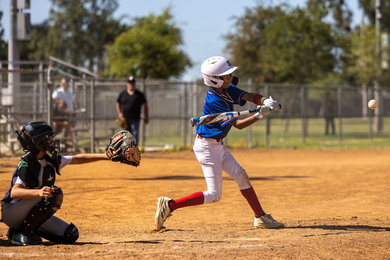 Baseball players in action on a dusty diamond field during a game.