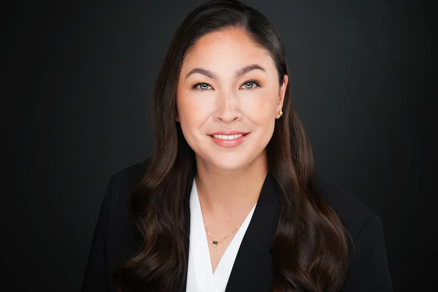 A series of professional headshot photos showing someone in dark business attire against a black background.