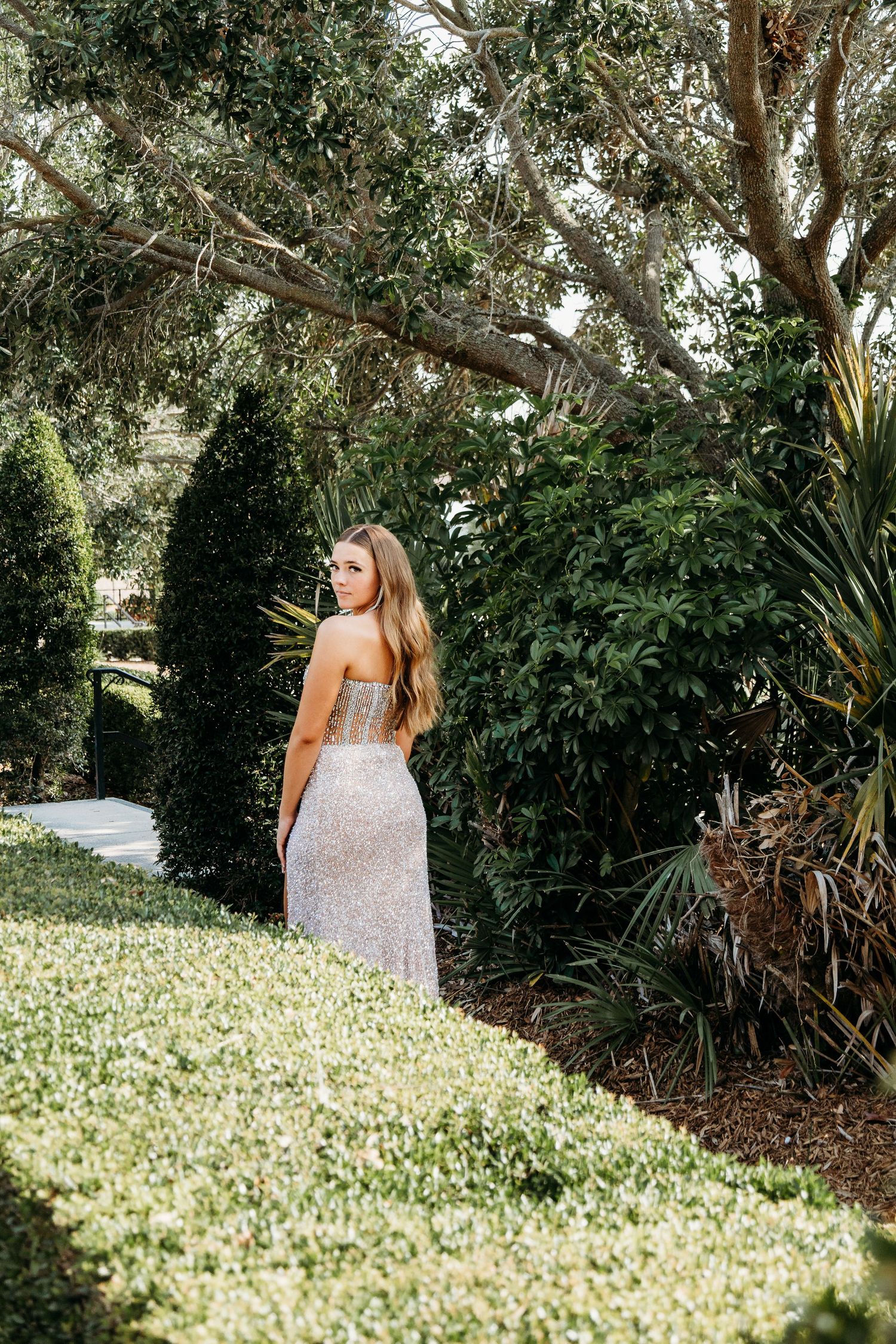 A white dress contrasts beautifully against a field of blooming flowers in a garden setting.
