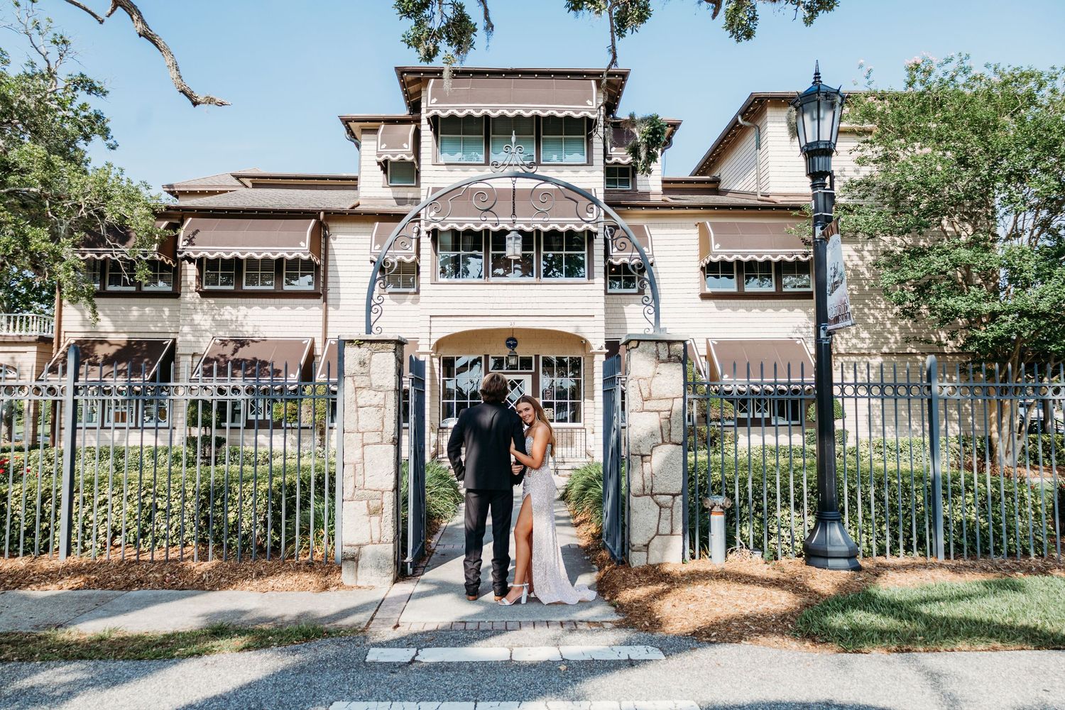 A Spanish-style building with wrought iron fencing creates an elegant architectural backdrop.