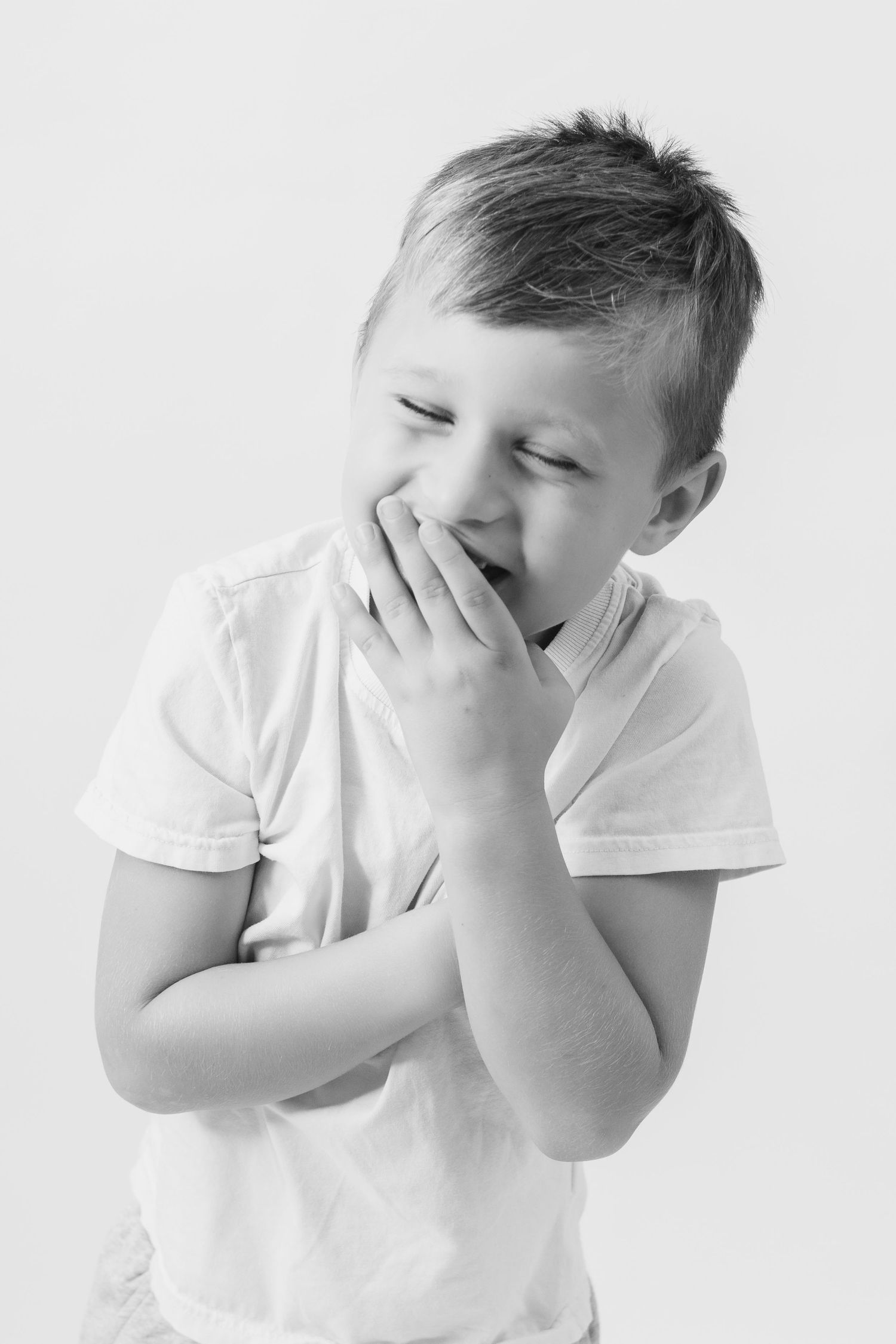 Black and white photo sequence showing a child in white shirt covering their face with hands in different poses.