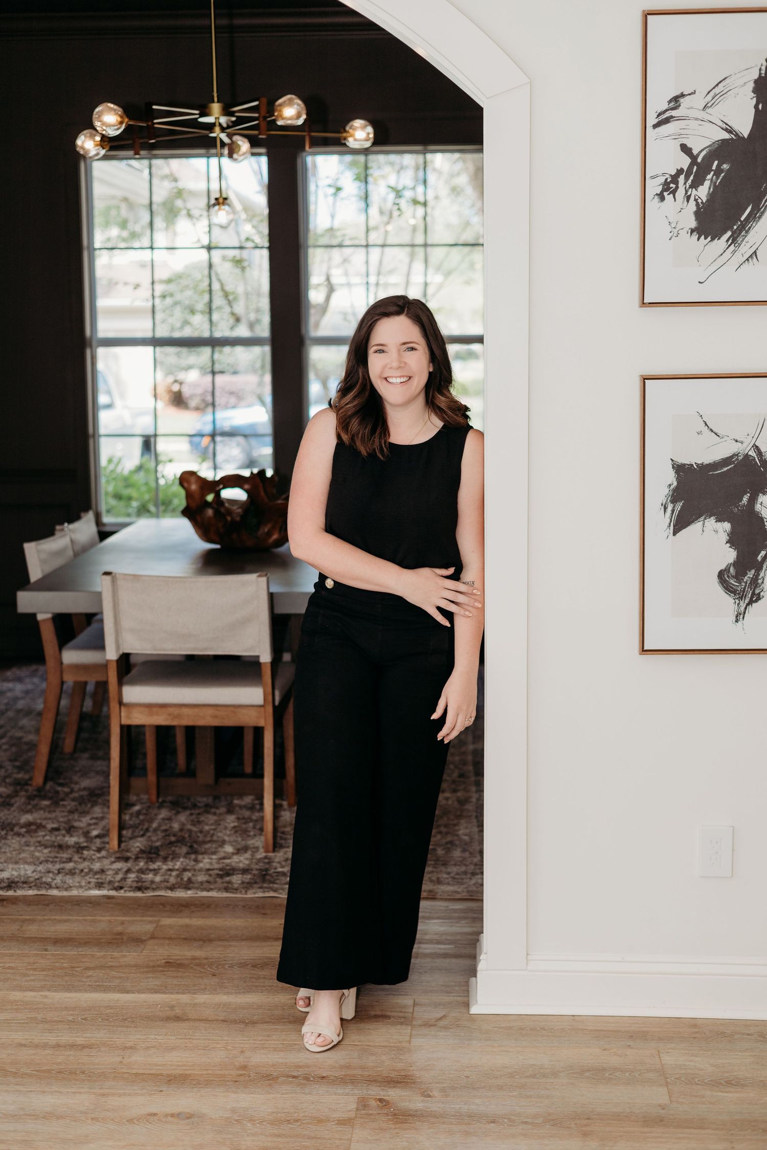 Contemporary dining room with black and white artwork and wooden flooring.