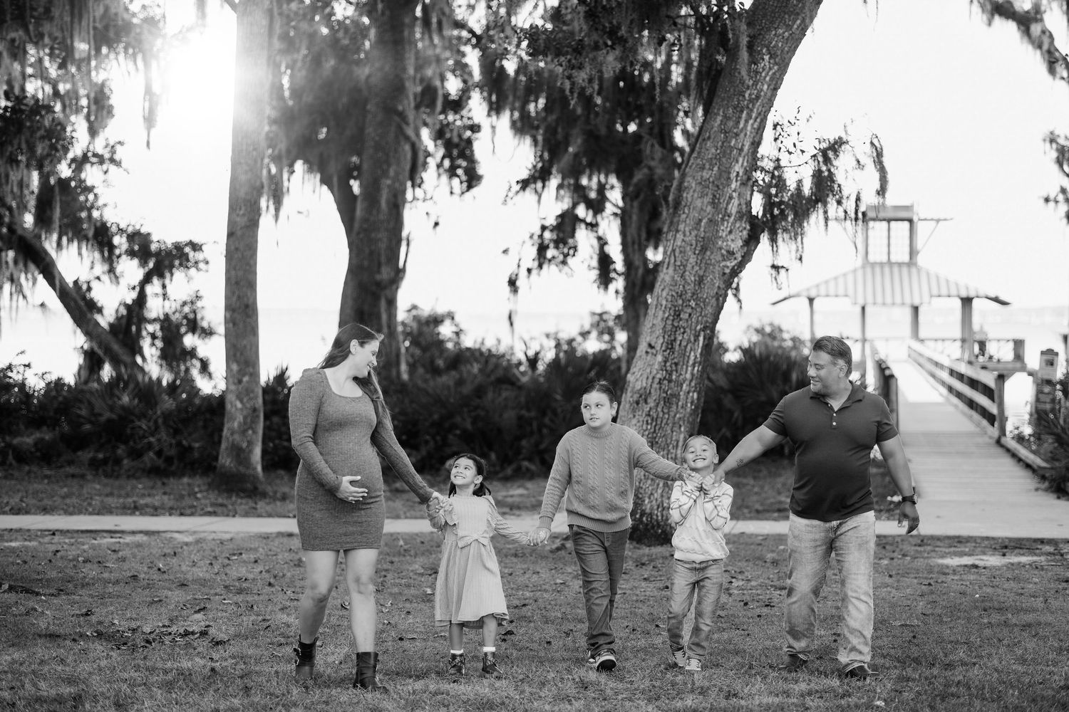 Black and white photos of family walking together under large oak trees.