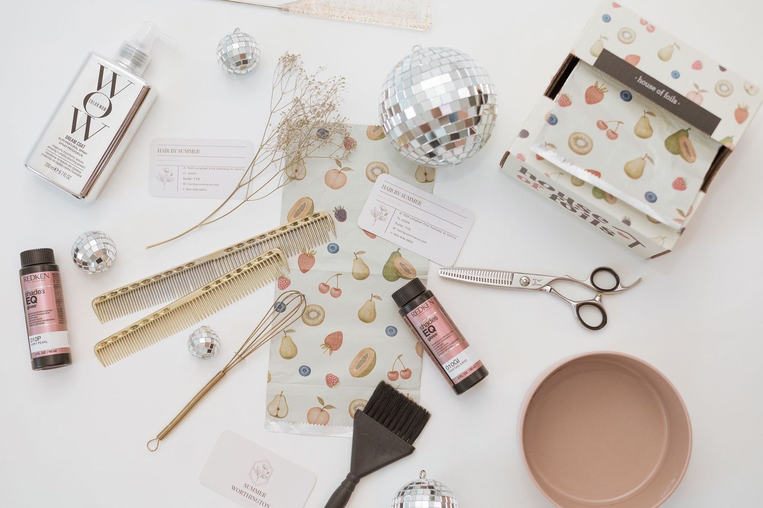 Flat lay of beauty and makeup products with feminine accessories on white background.