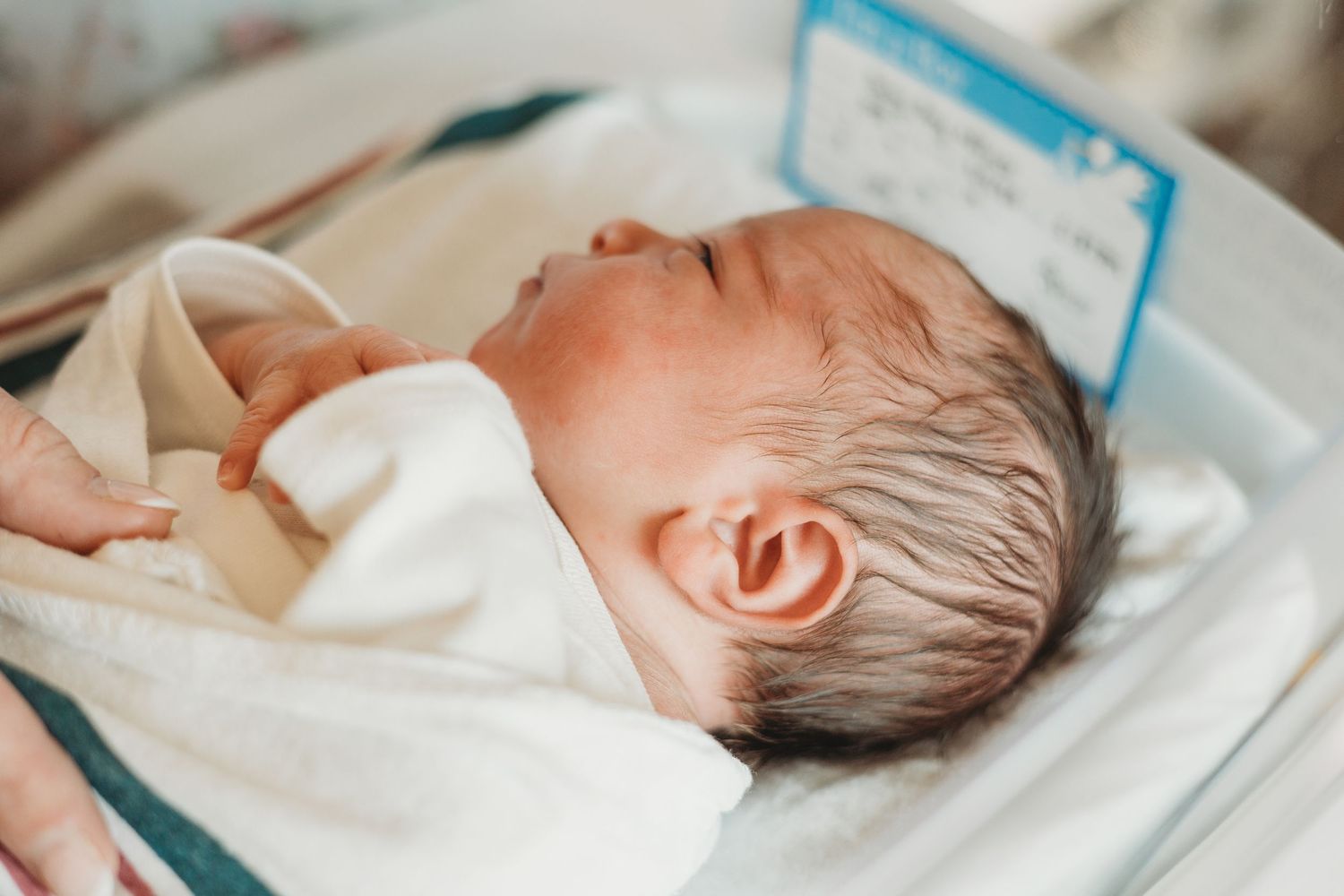 Sleeping newborn baby resting peacefully in a hospital bassinet.