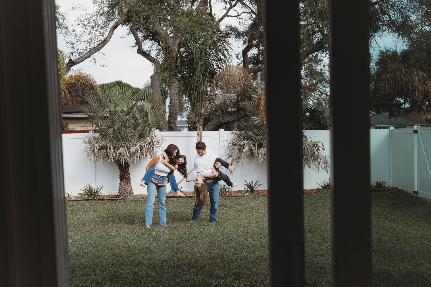 People enjoying outdoor activities in a grassy park area with trees in the background.