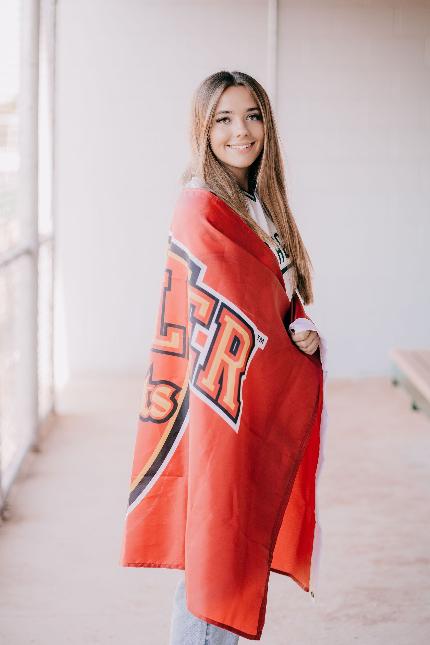 Playful poses with a bright red sports jersey against a light background.