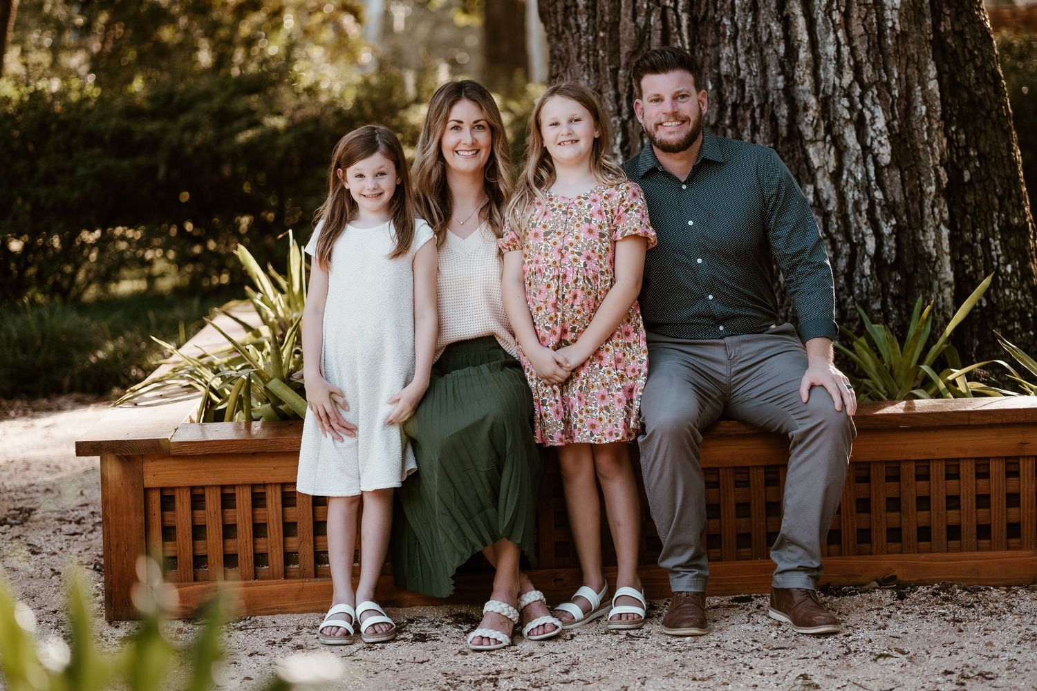 Family group portrait session on rustic wooden deck with natural lighting.