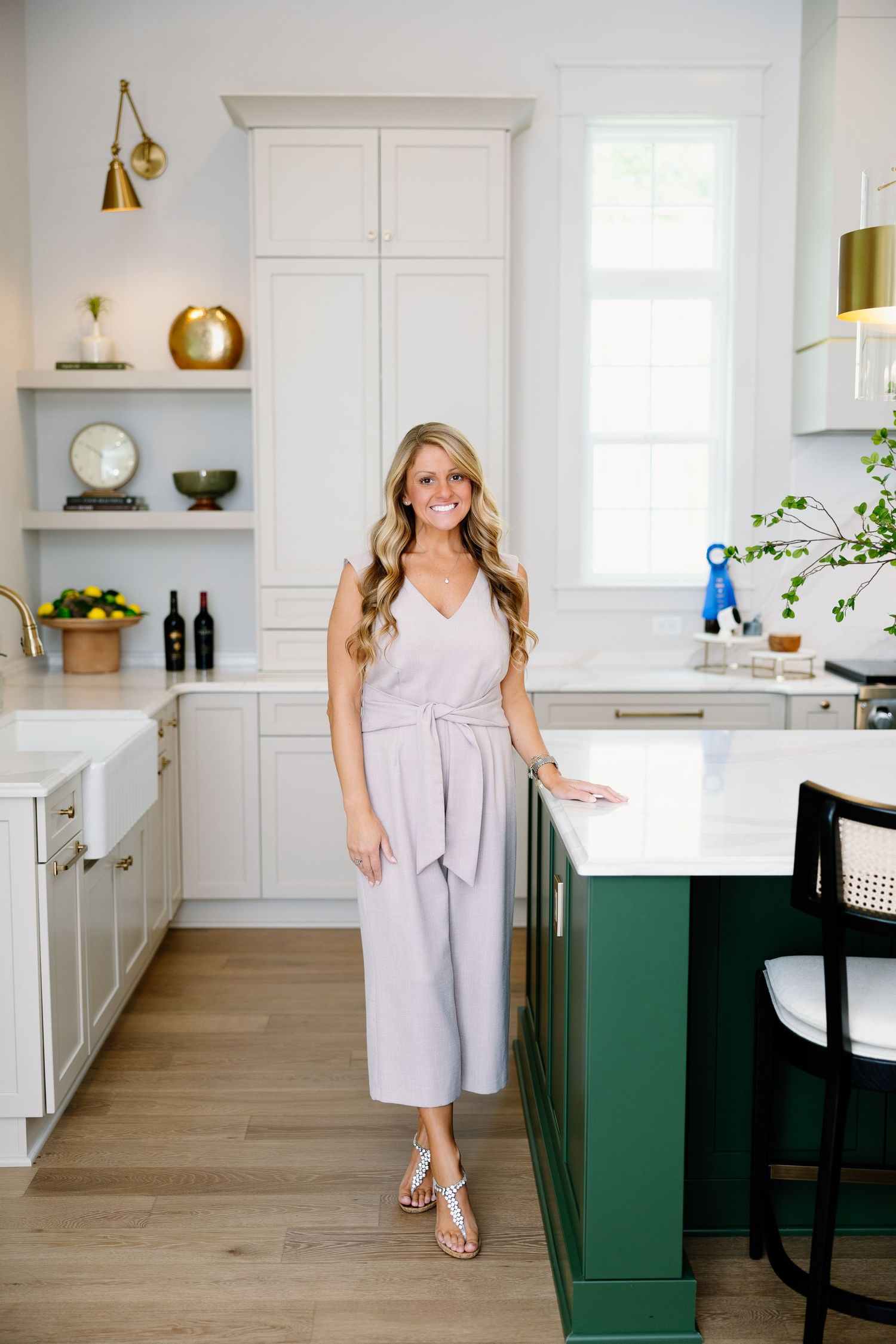 Lifestyle photos in modern white kitchen with green island and gold accents.