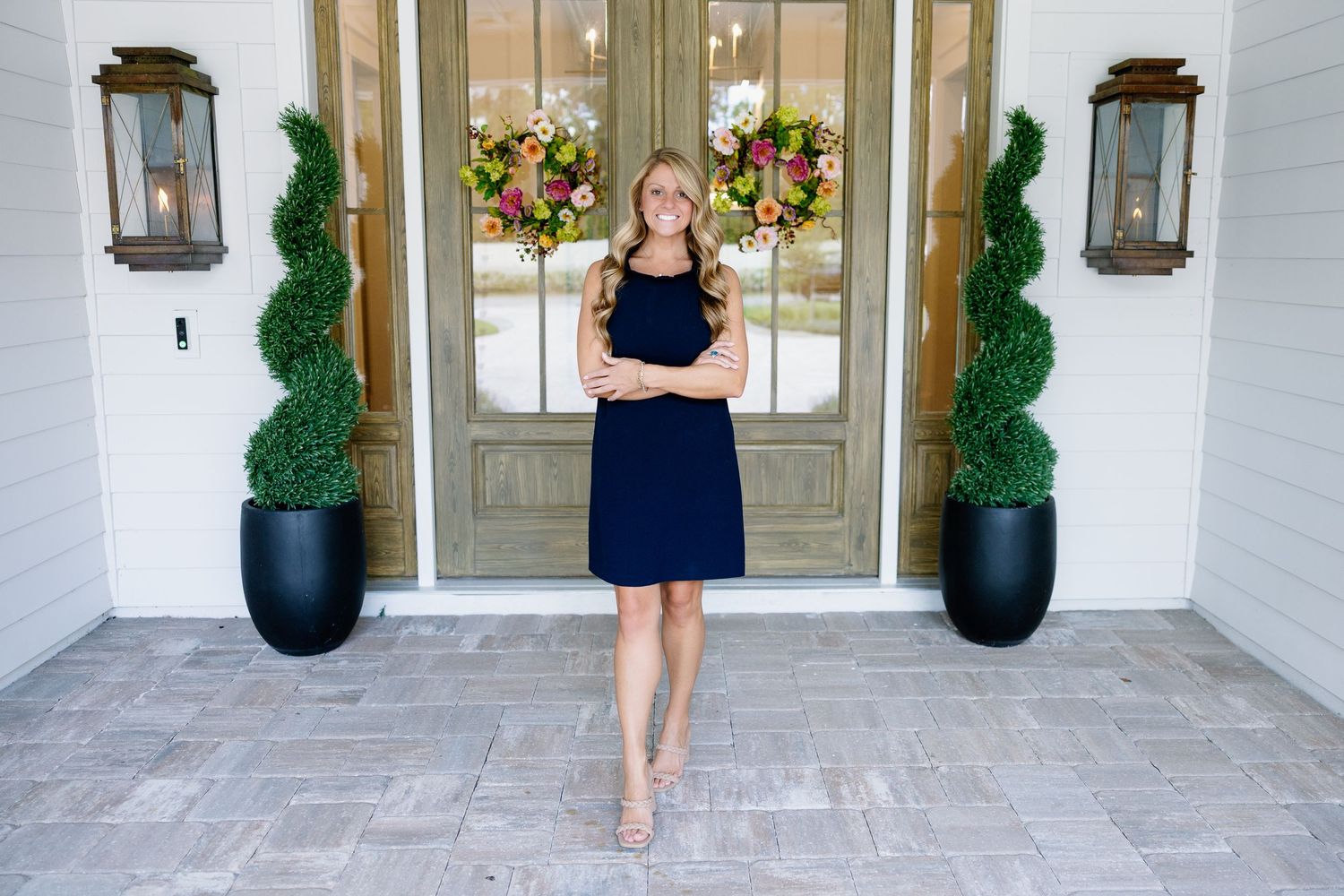 Elegant outdoor entrance with potted plants and glass doors.