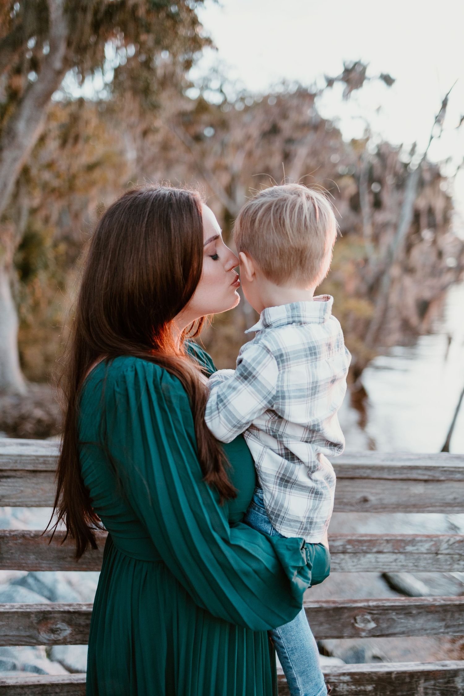 A tender moment shared between parent and child in a green sweater against an autumn backdrop.