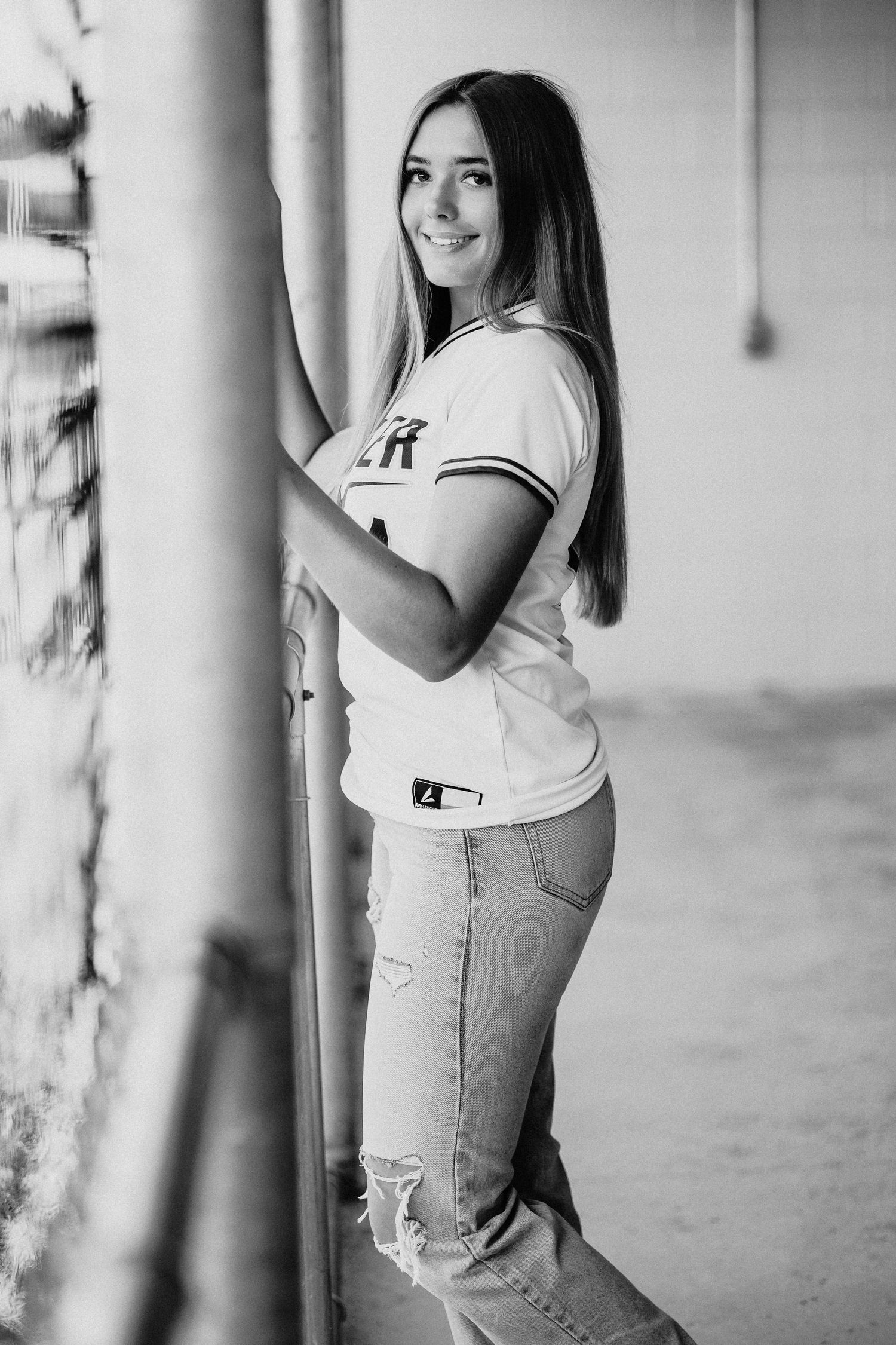 A casual photoshoot in a hallway wearing ripped jeans and a white t-shirt.