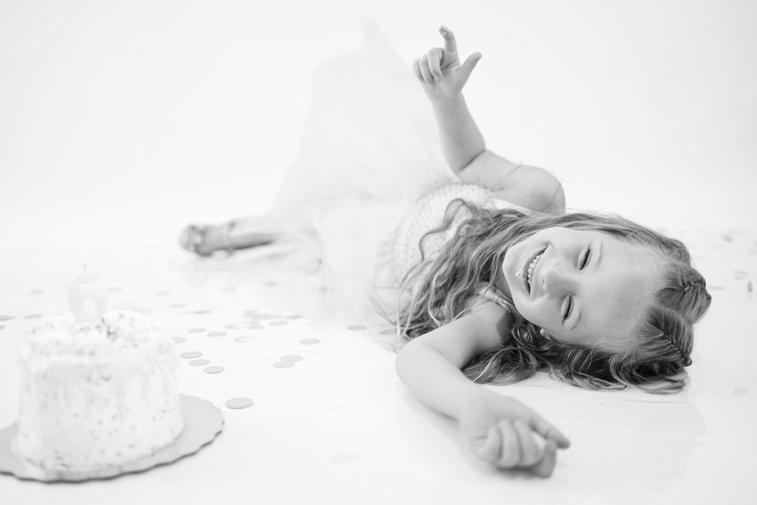 A series of black and white artistic portraits showing a figure in flowing white fabric lying on the ground.