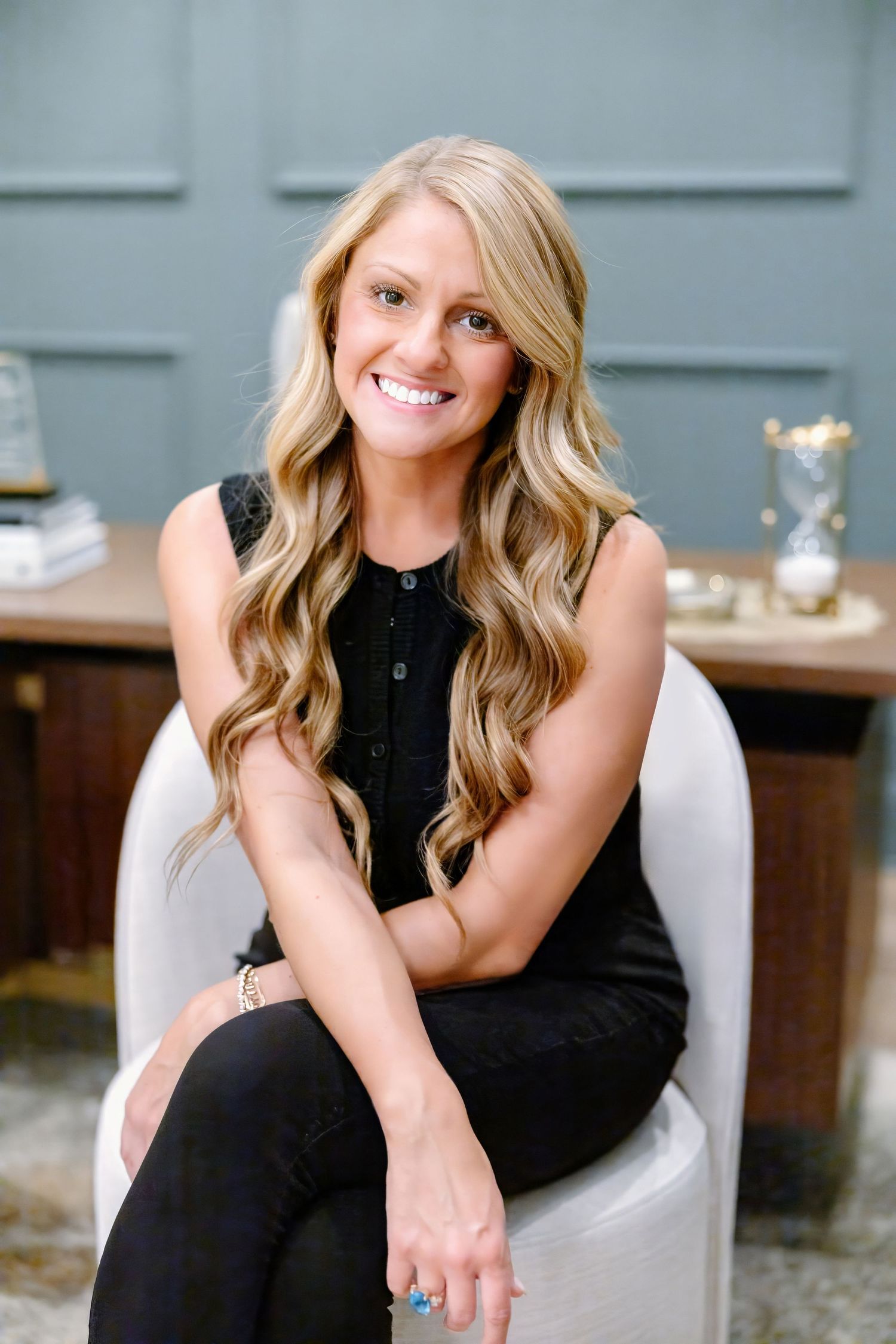Elegant black outfit photographed in a modern studio setting with grey walls.