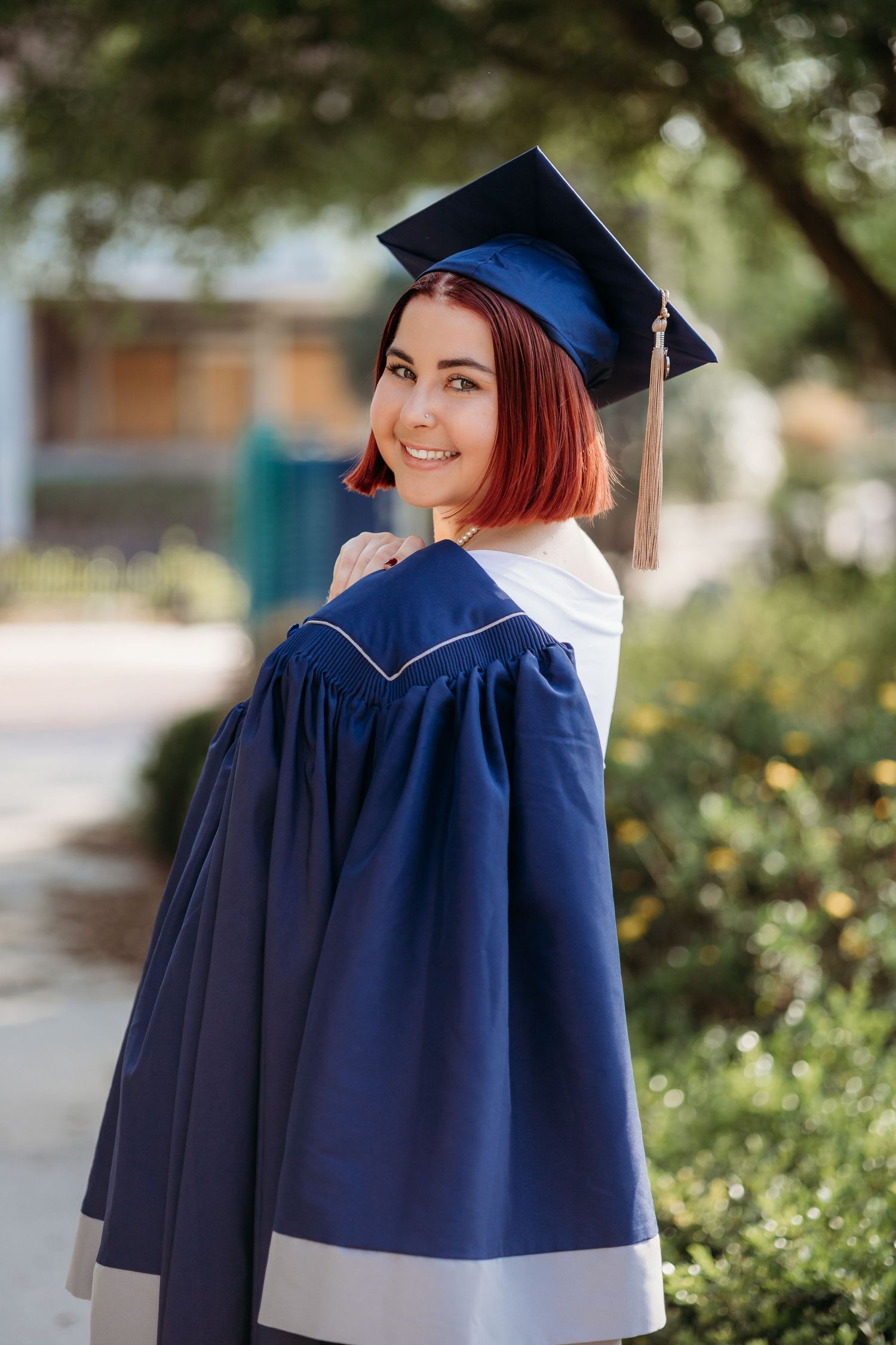 A graduation photoshoot sequence showing different poses in a navy blue cap and gown outdoors.