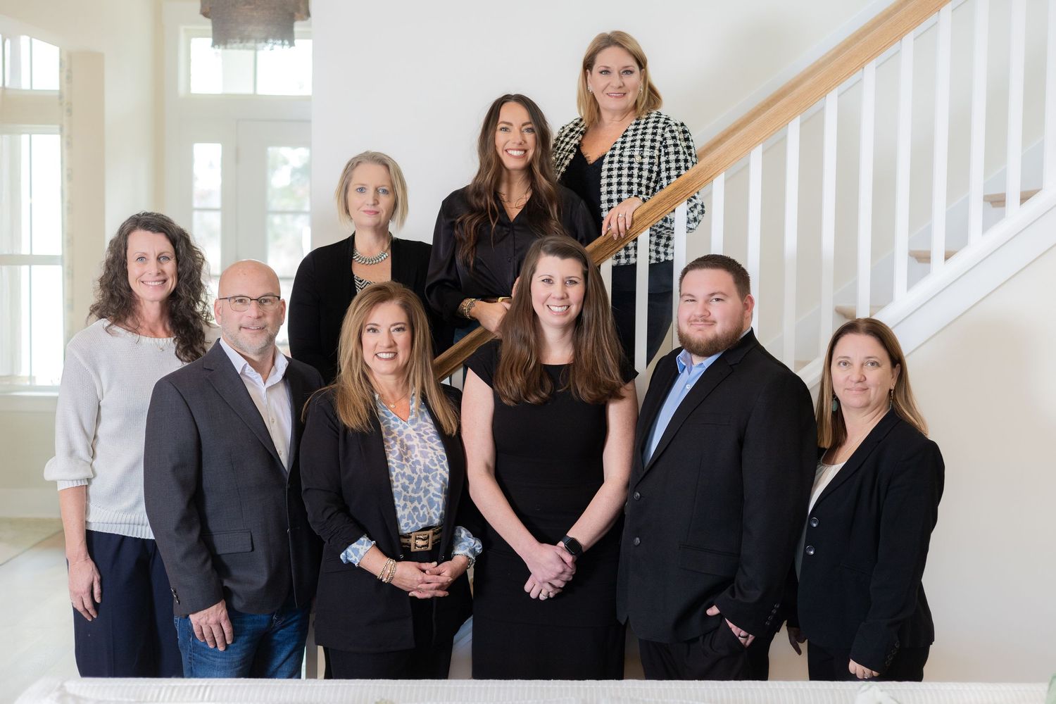 Professional business team posing for group photo on staircase.