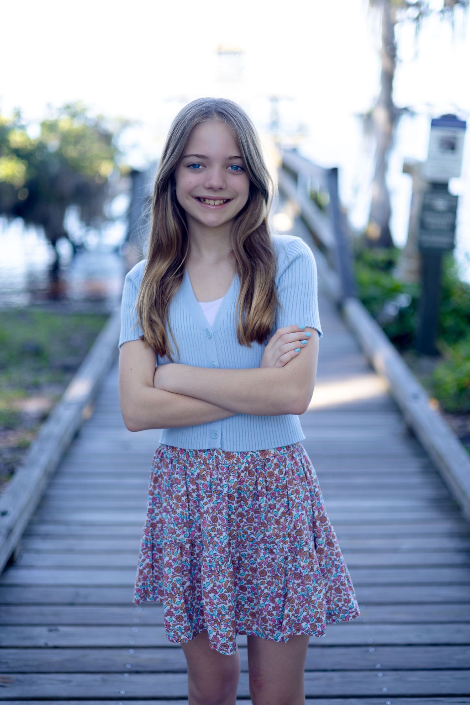 Portrait series on wooden boardwalk showing person in blue top and floral skirt.