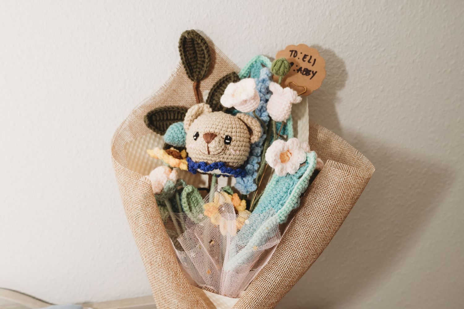 Collection of baby items including soft toys and blankets in pastel colors.