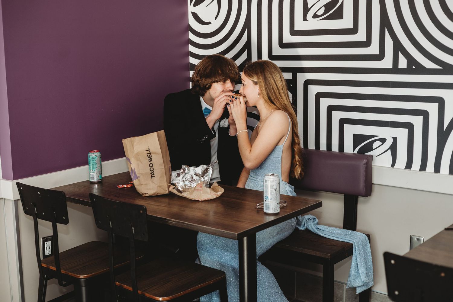 Restaurant interior with black and white geometric wall pattern and blue chairs.