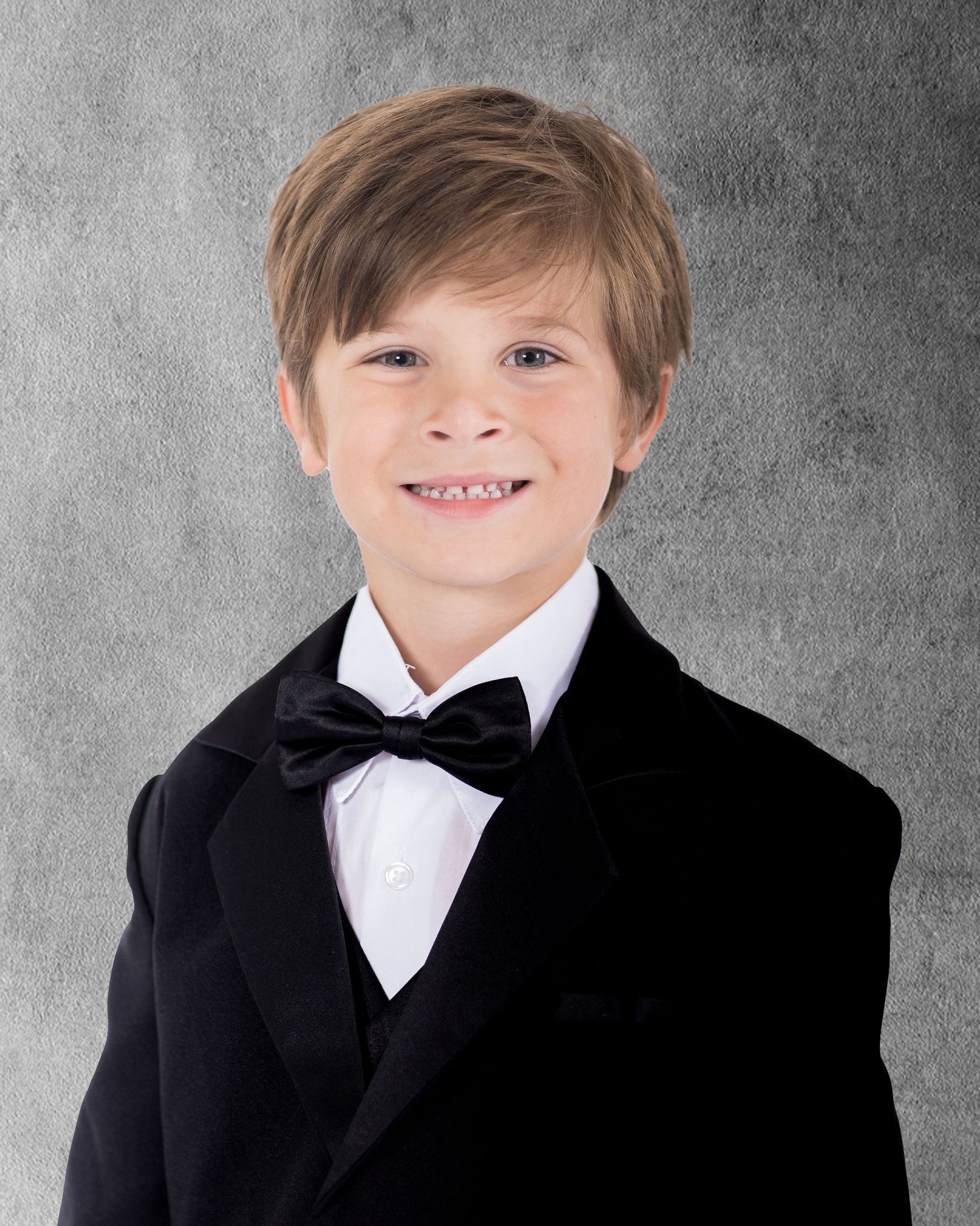 Formal portrait series showing child in black tuxedo and bowtie against grey background.
