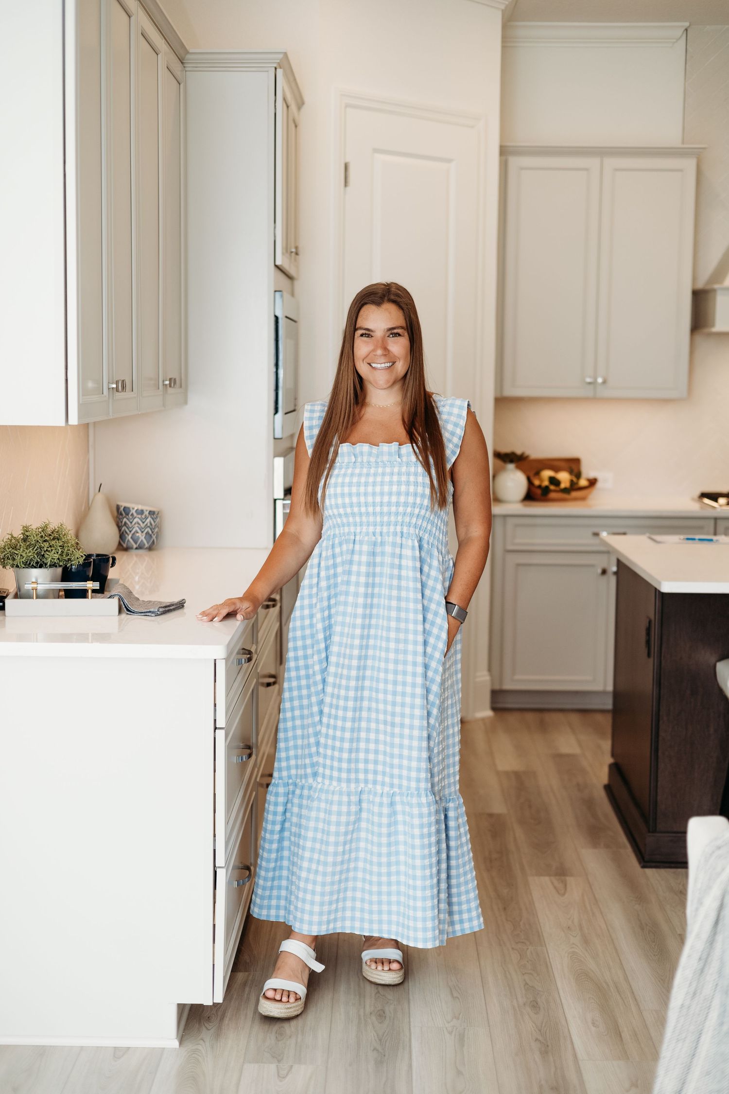 Light blue gingham dress shown in a modern white kitchen setting.