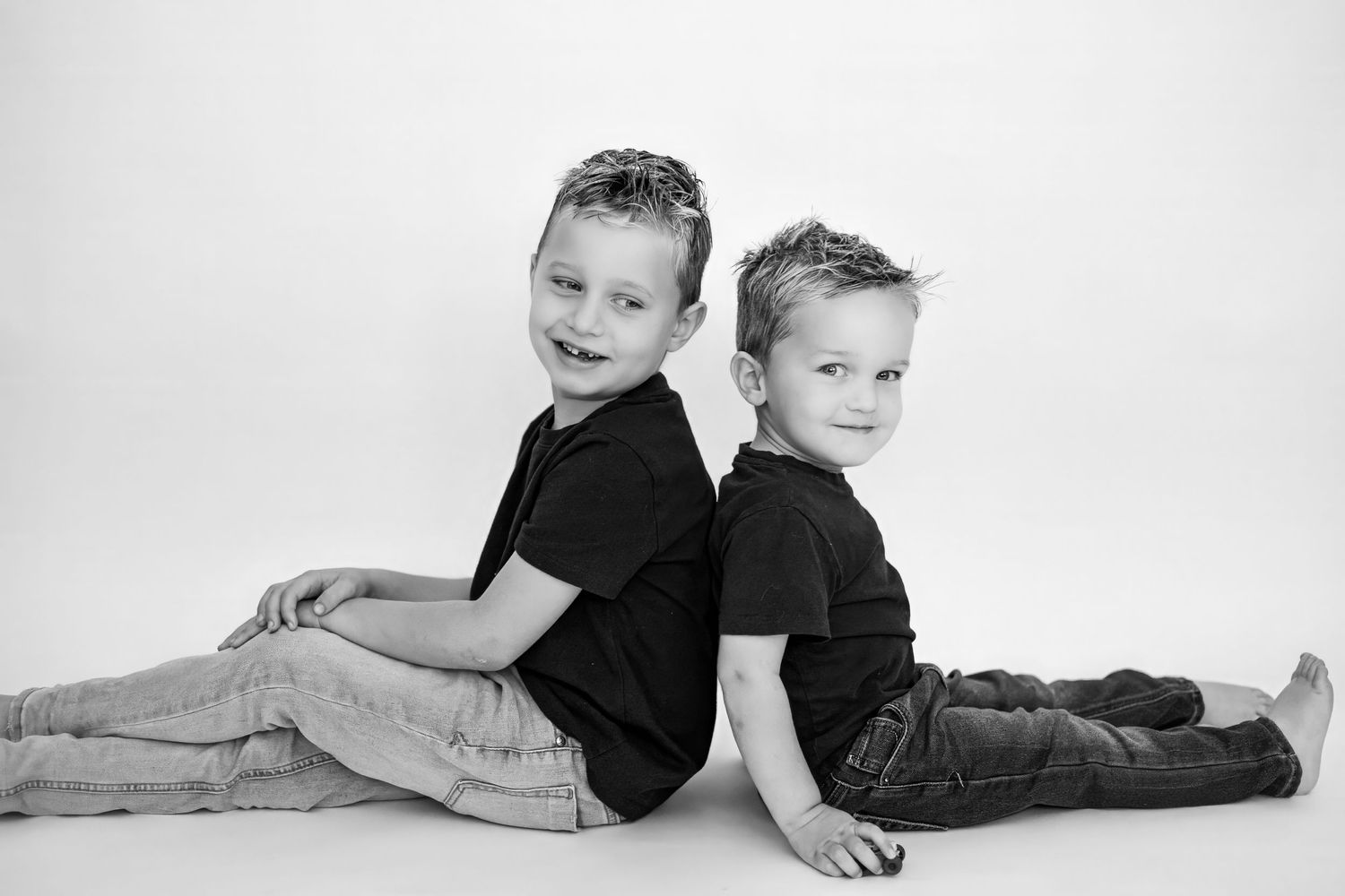 A black and white photo series showing children lying down and posing playfully in casual clothing.