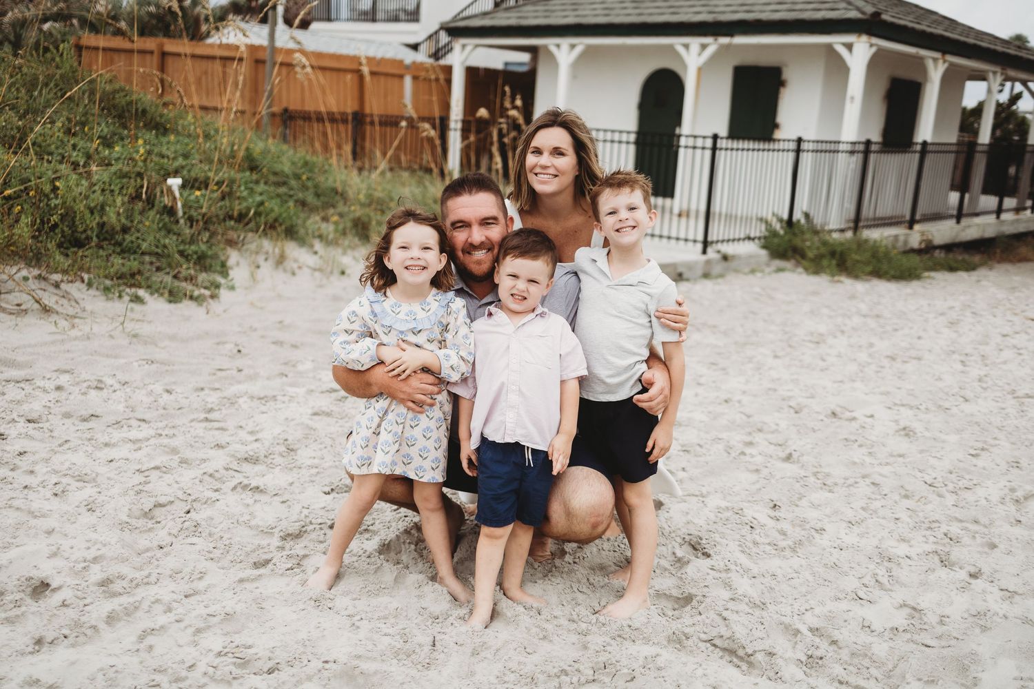 Family enjoying a casual day together on a sandy beach with matching outfits in a series of candid moments.