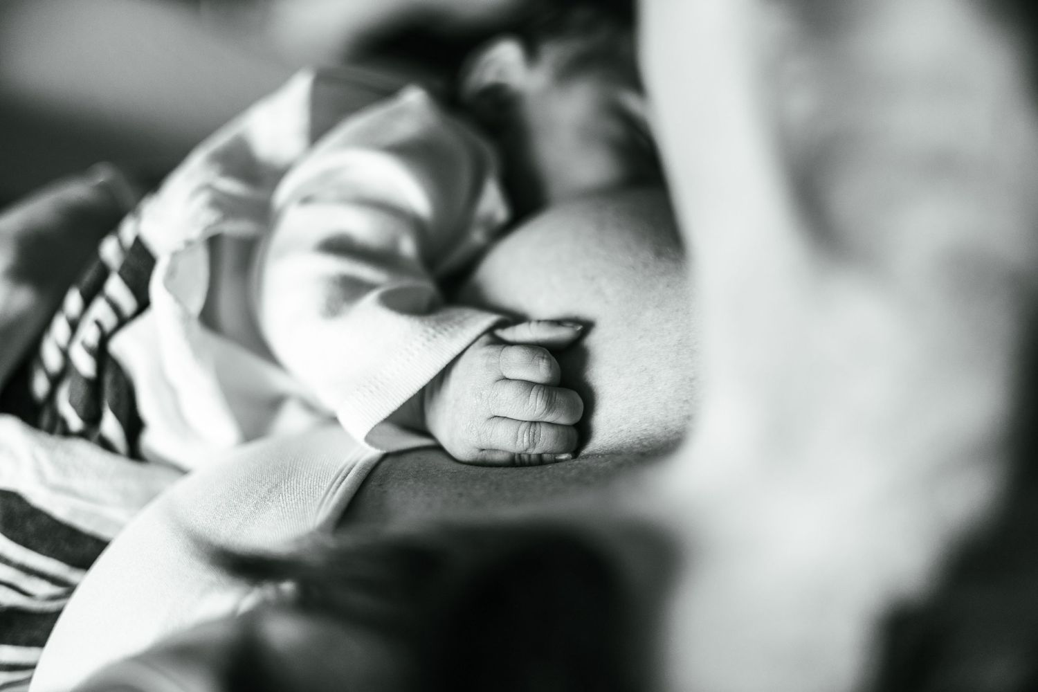 Artistic black and white close-up shots showing tender moments with a baby.