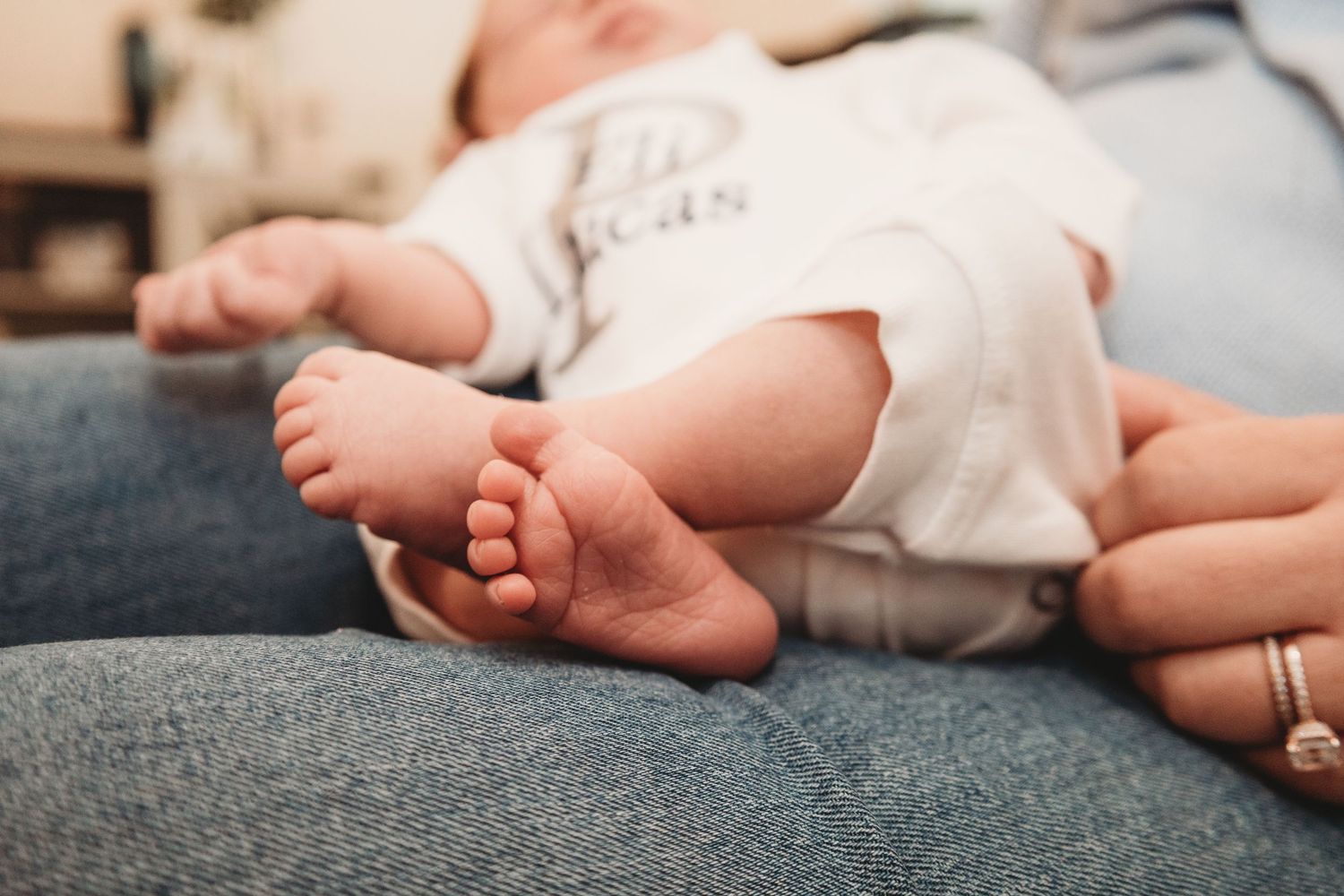 Close-up of tiny newborn baby feet against a soft white blanket.