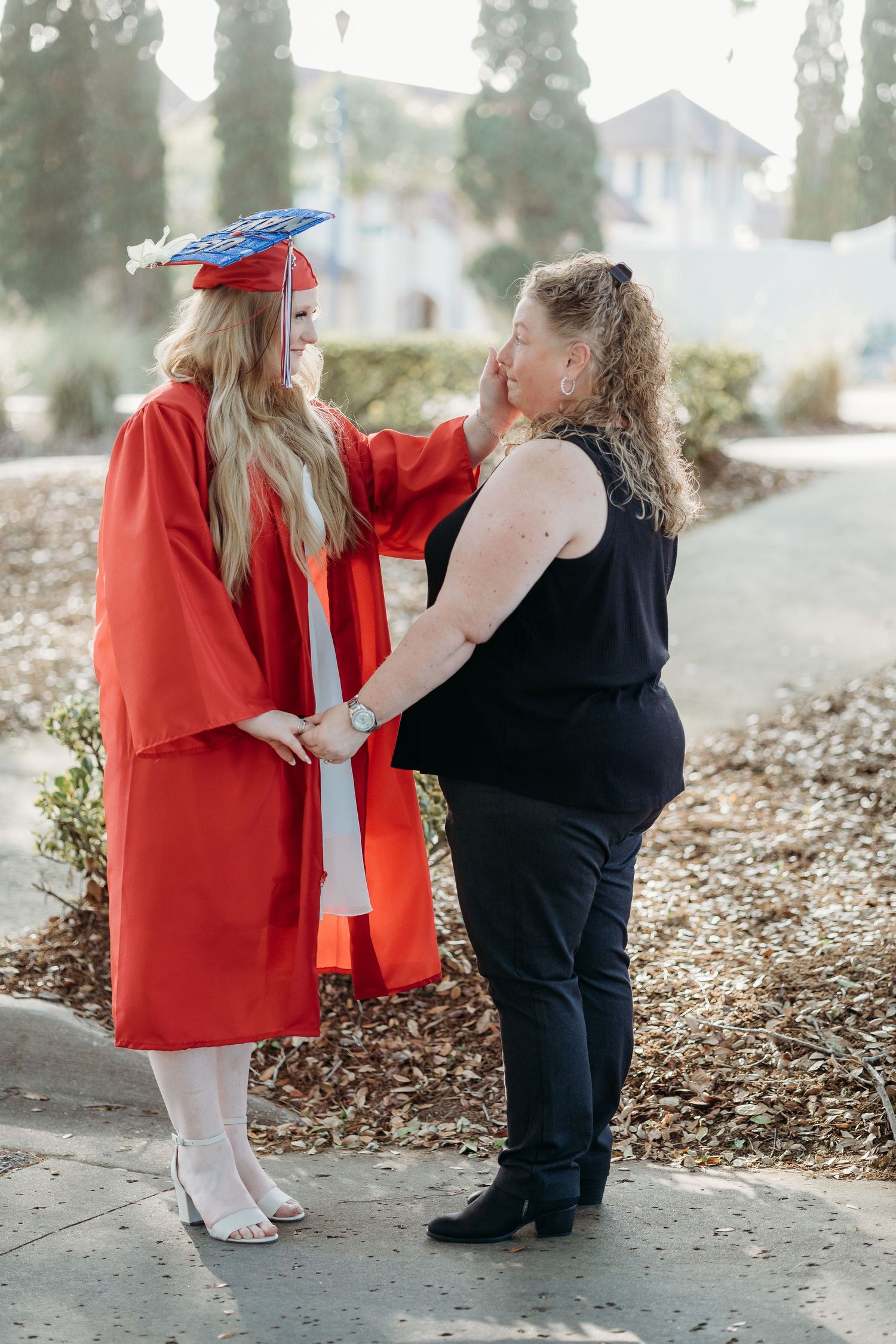 Graduation photos showing interactions between two people in red and black attire.