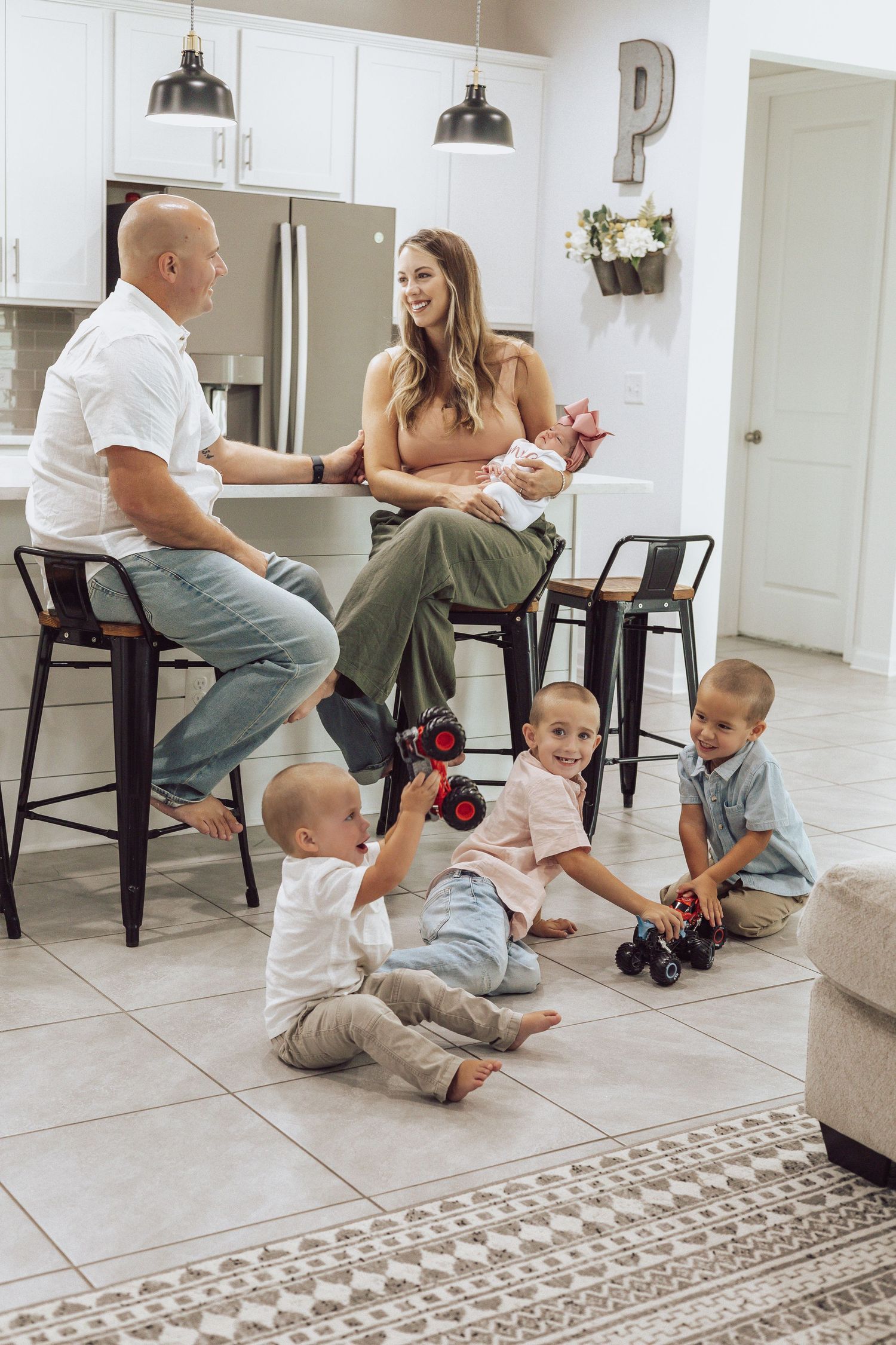 Family sitting together on a tiled floor with toys scattered around during playtime.