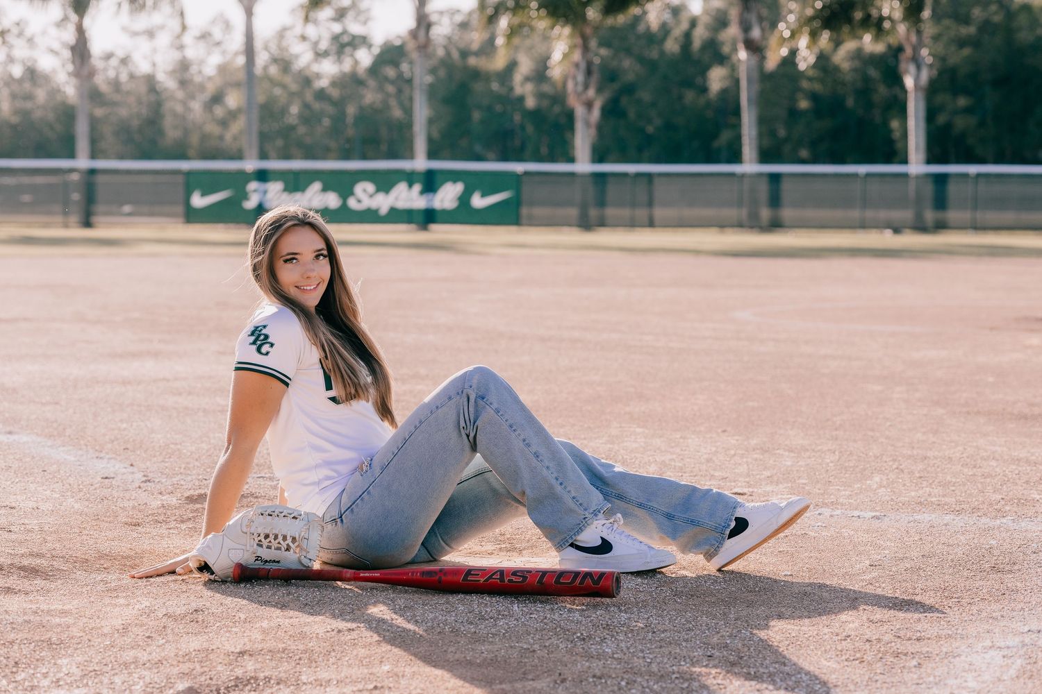 A casual portrait session on a baseball field with soft evening lighting.