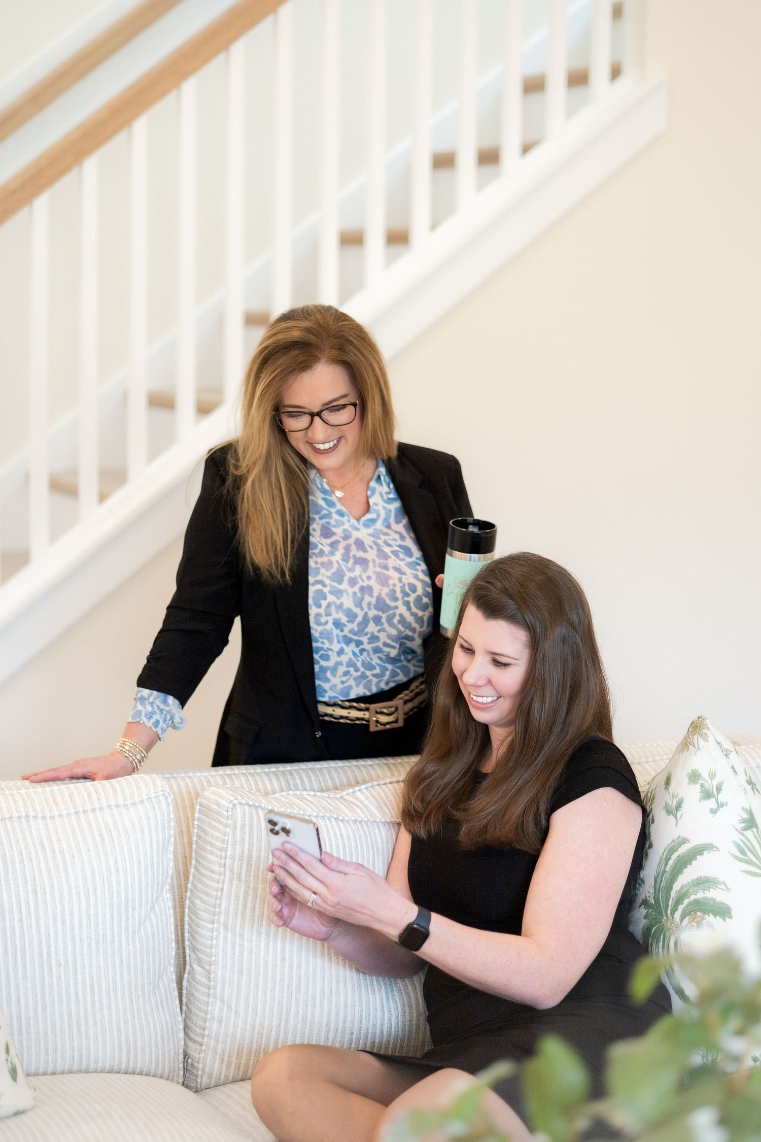Two professionals reviewing documents together on couch.