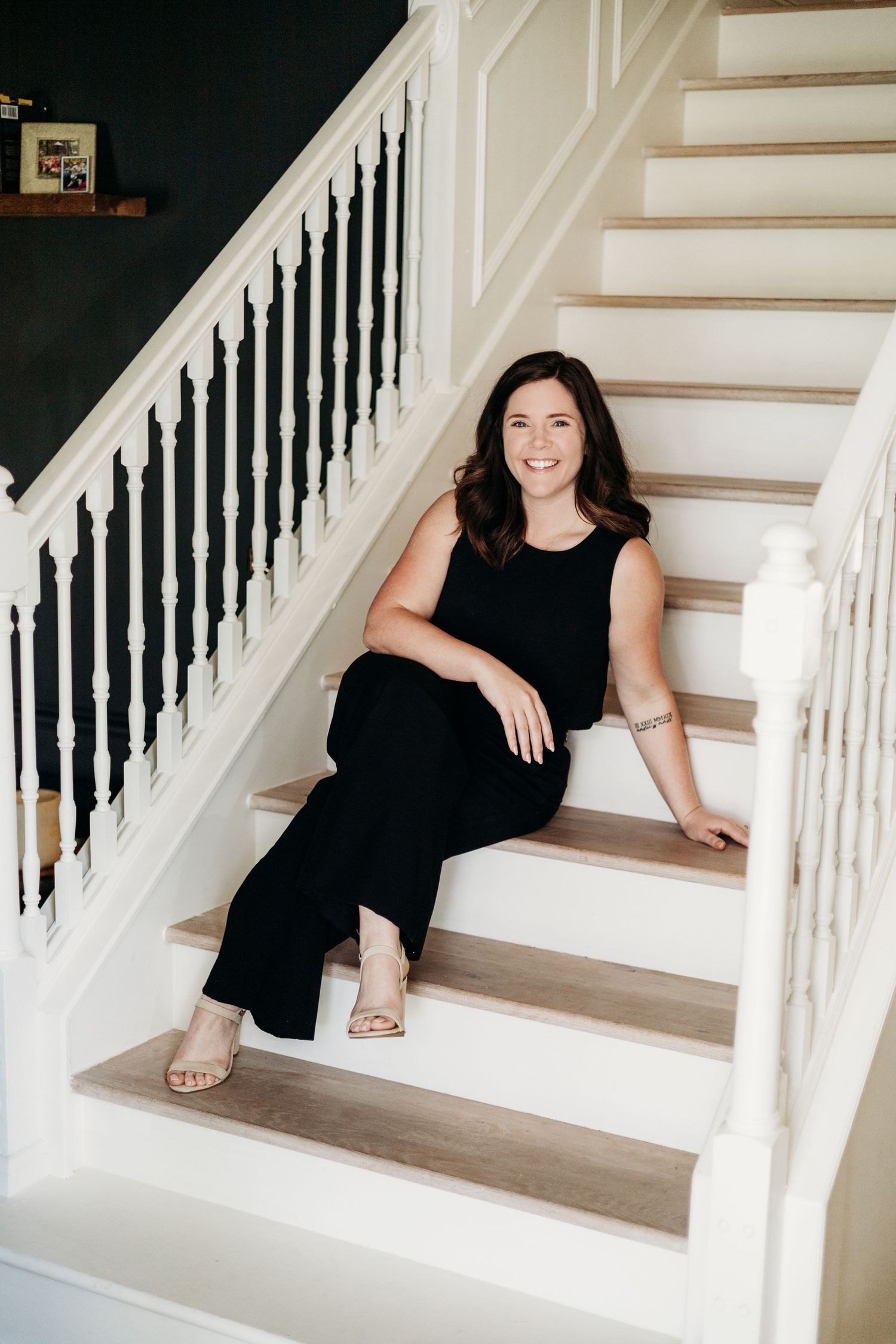 Professional headshots on white stairs showing different casual poses in black attire.