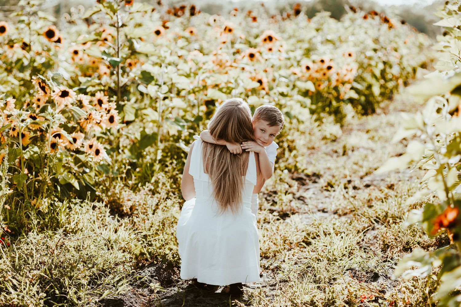 A dreamy outdoor photoshoot in a field of wildflowers during golden hour with soft sunlight filtering through.