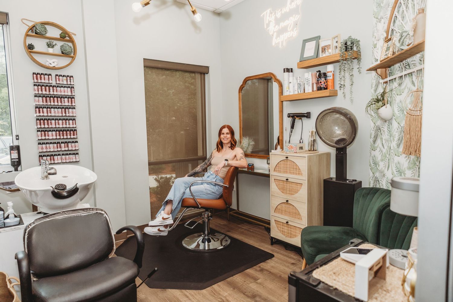 Stylish beauty salon workspace with rattan accents and green velvet seating.
