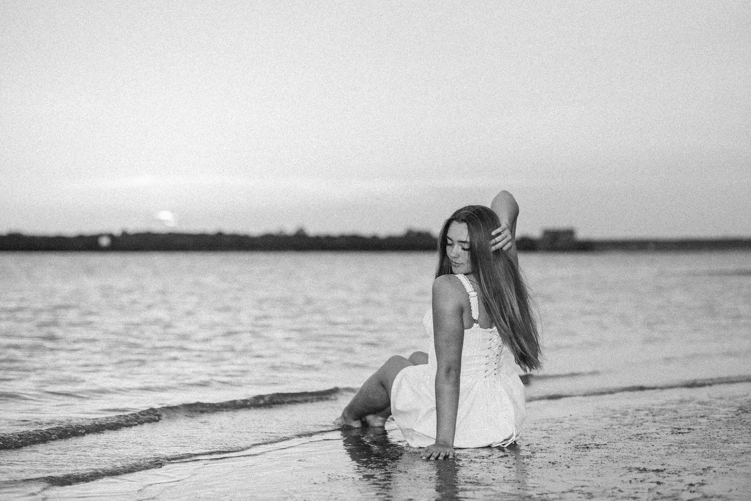 Minimalist black and white beach photography with water reflections.