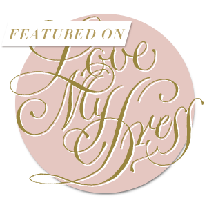 Elegant gold 'Featured On Love My Dress' logo design on a soft pink circular background.