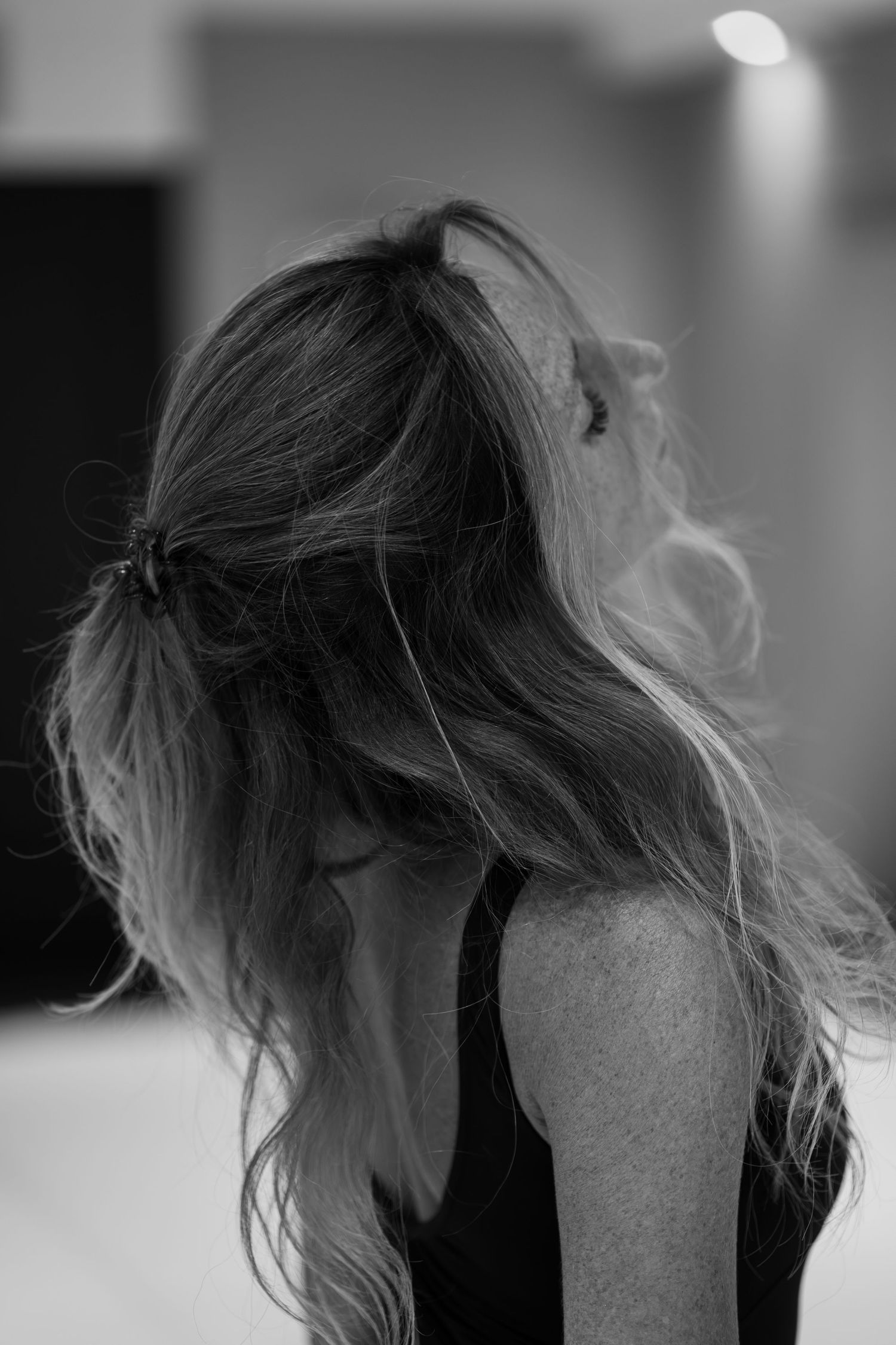A black and white photo sequence showing hair movement in a dynamic flowing motion against a dark background.