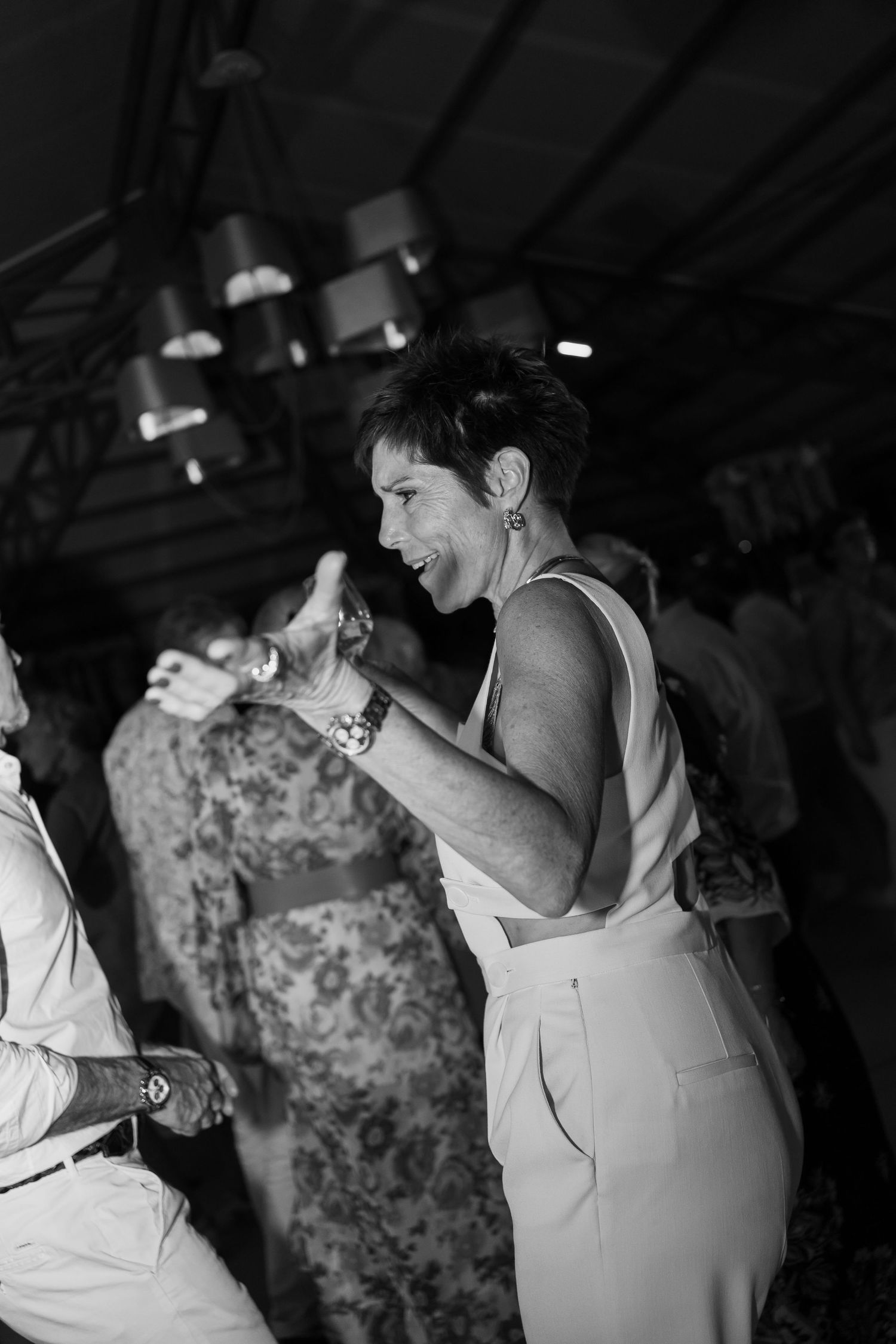 Black and white sequence of a person taking a bite of food at what appears to be a wedding reception or party.