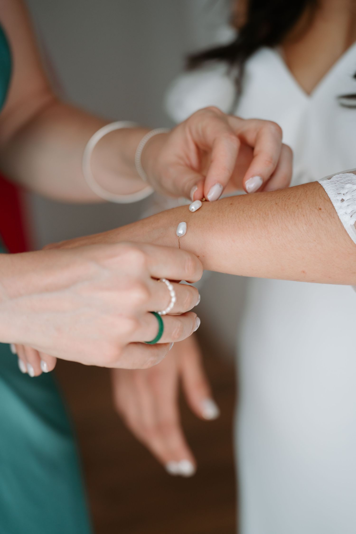 A close-up series of hands performing a medical examination or health check on someone's arm.