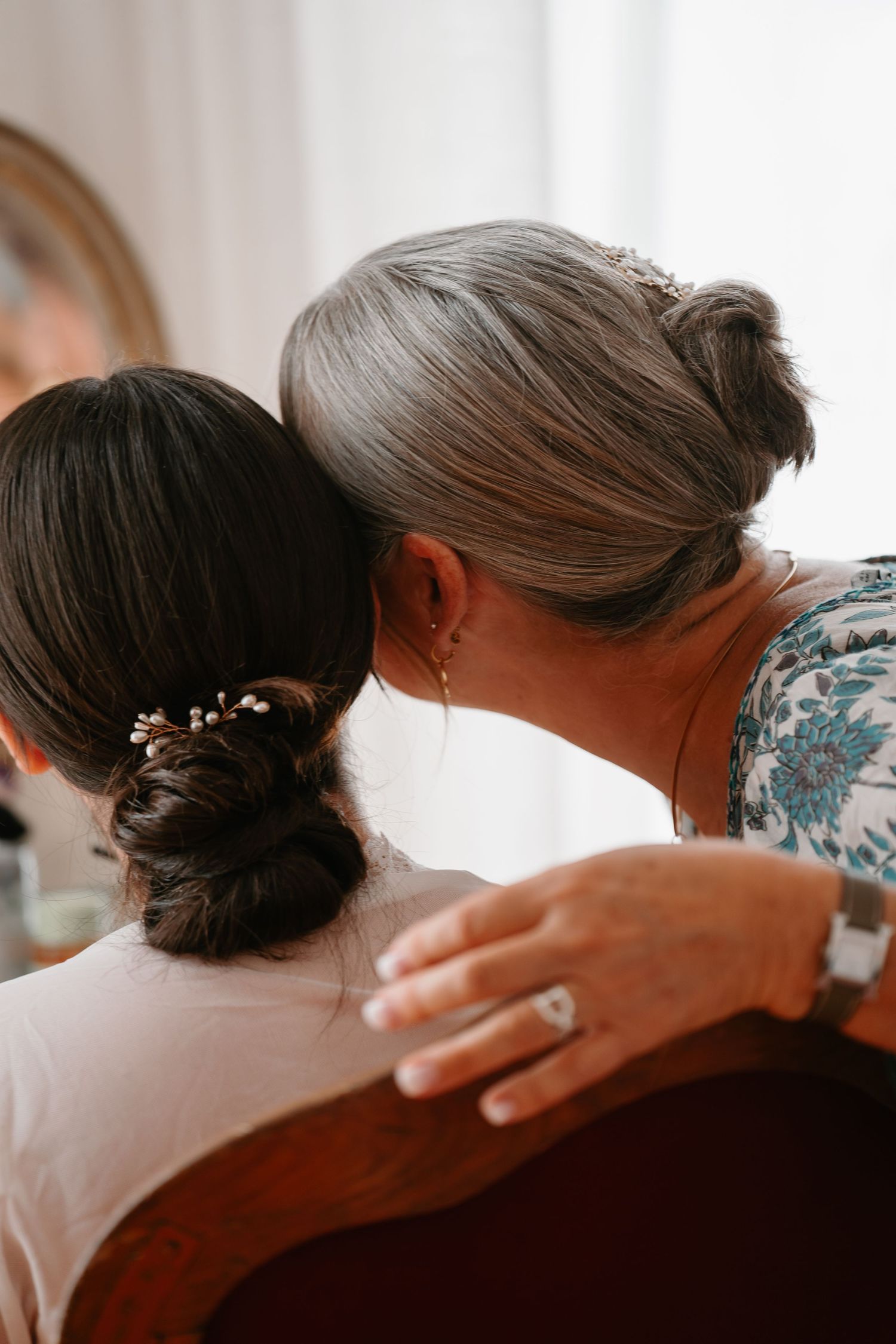 A tender moment captured in warm lighting as a person gently places their hand on another's neck in an intimate gesture.
