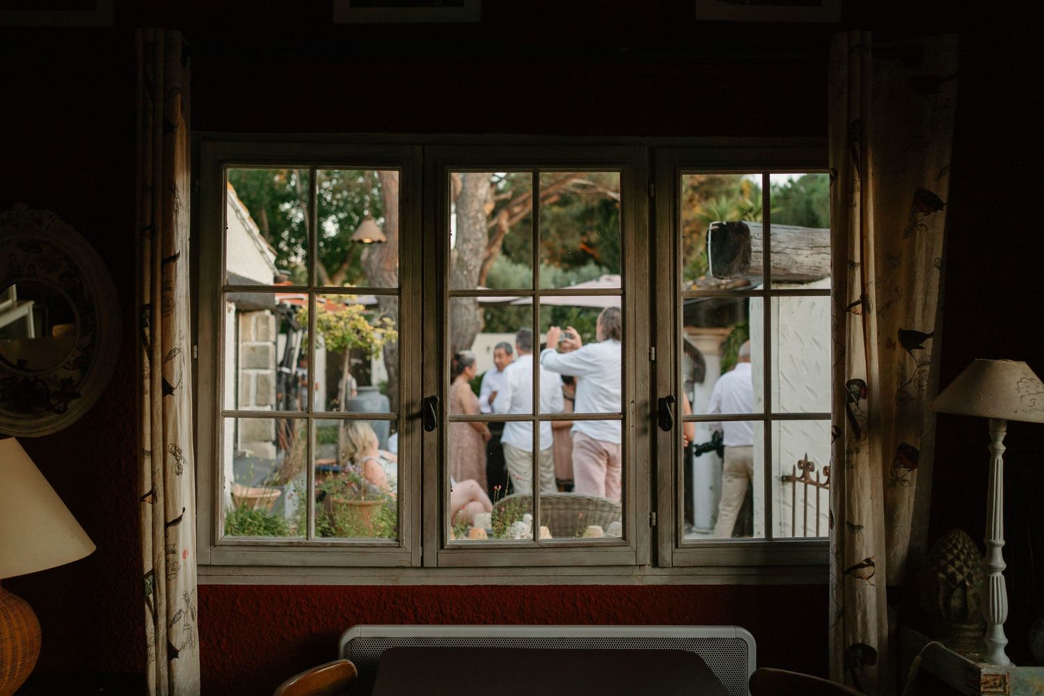 Rustic wooden cabin interior with vintage furniture, windows, and natural light streaming in through glass panes.