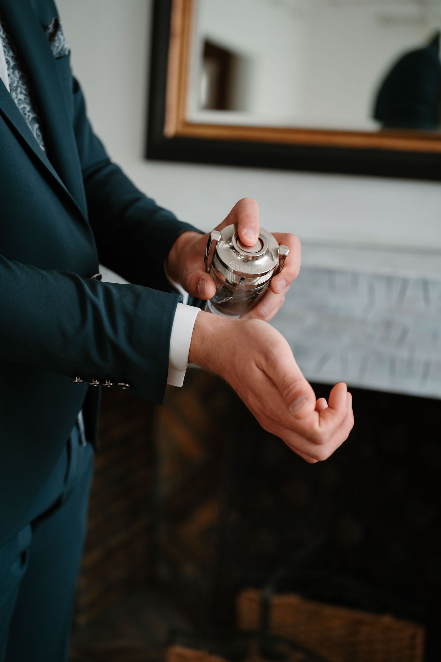 Close-up shots of hands adjusting cufflinks and watch while wearing a navy blue suit.