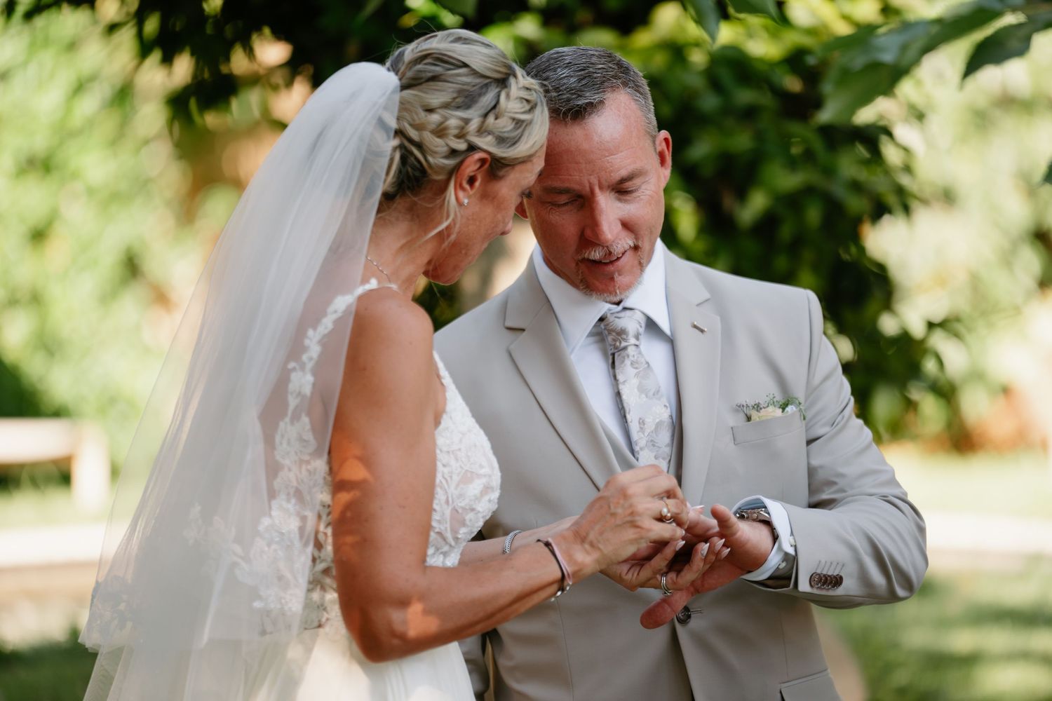 Bride and groom share a joyful moment together during their outdoor garden wedding ceremony.