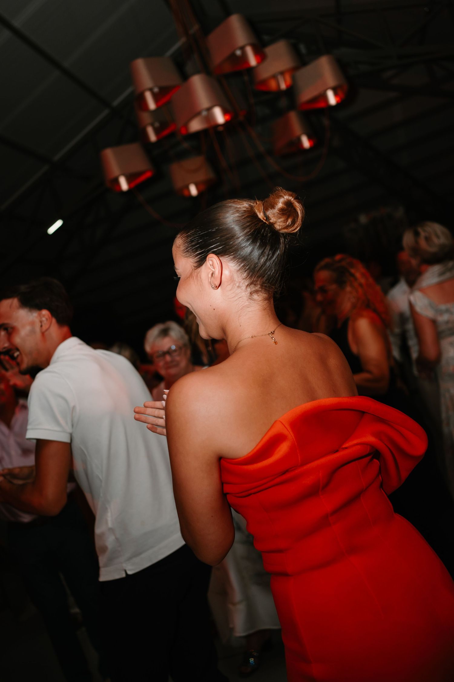 A sequence of dance party photos showing people dancing in a dimly lit venue with red lighting and festive atmosphere.
