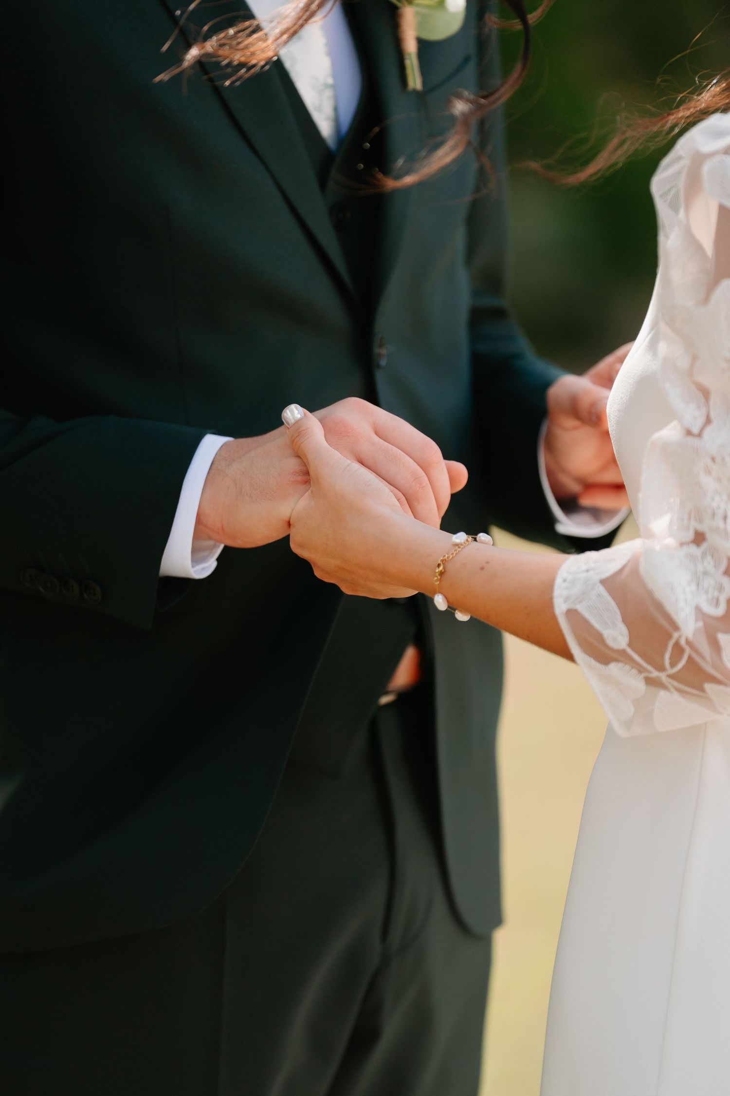 Close-up view of hands exchanging wedding rings during a traditional marriage ceremony.