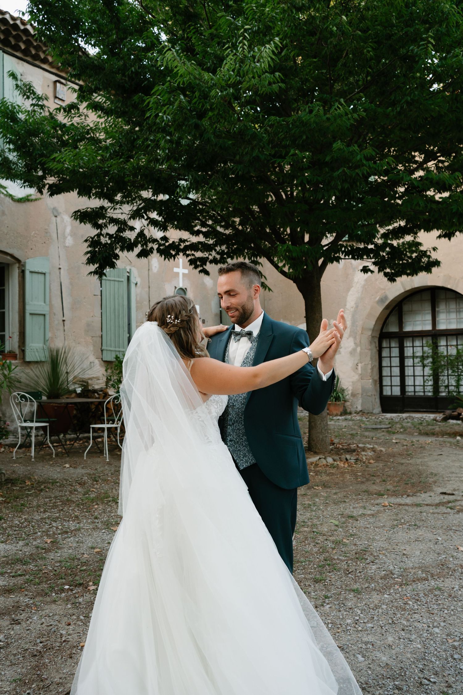 A romantic first dance moment between newlyweds in a charming outdoor courtyard setting.