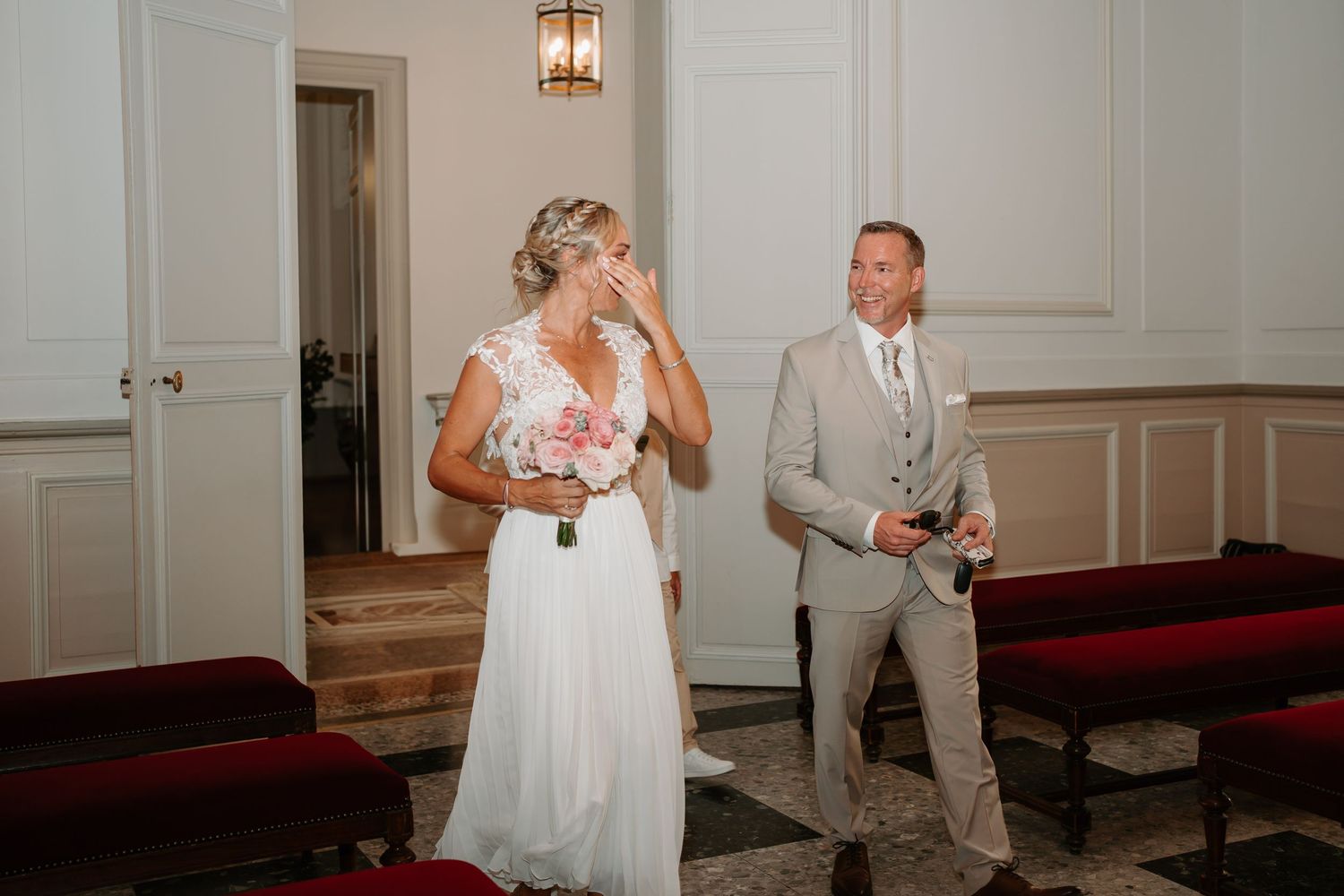 A bride and groom share their first dance together on a hardwood floor at their wedding reception.