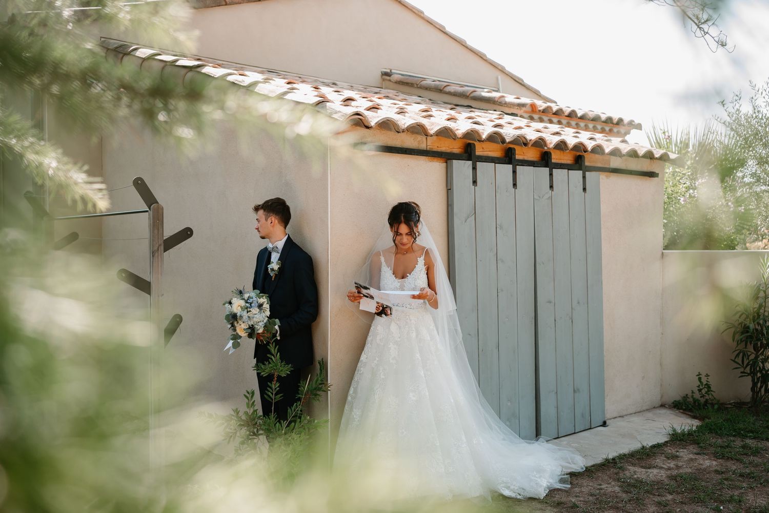 Wedding ceremony setting with rustic white walls and blue shutters.